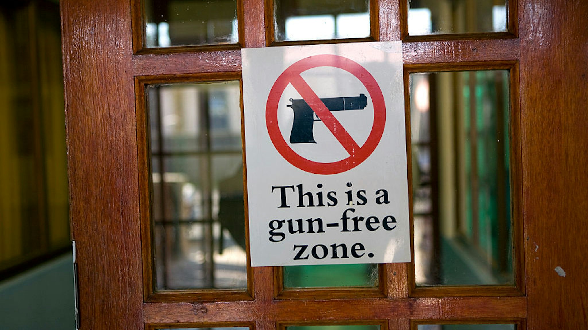 A Gun free zone sign on the entrance door of the Lavender Hill township Community Centre in the Cape Town region of South Africa. (Photo by In Pictures Ltd./Corbis via Getty Images)