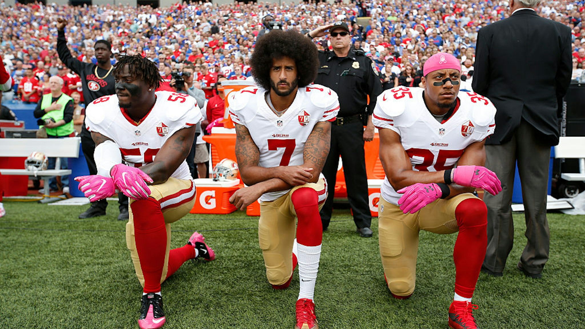 ORCHARD PARK, NY - OCTOBER 15: Eli Harold #58, Colin Kaepernick #7 and Eric Reid #35 of the San Francisco 49ers kneel in protest on the sideline, during the anthem, prior to the game against the Buffalo Bills at New Era Field on October 16, 2016 in Orchard Park, New York. The Bills defeated the 49ers 45-16. (Photo by Michael Zagaris/San Francisco 49ers/Getty Images)