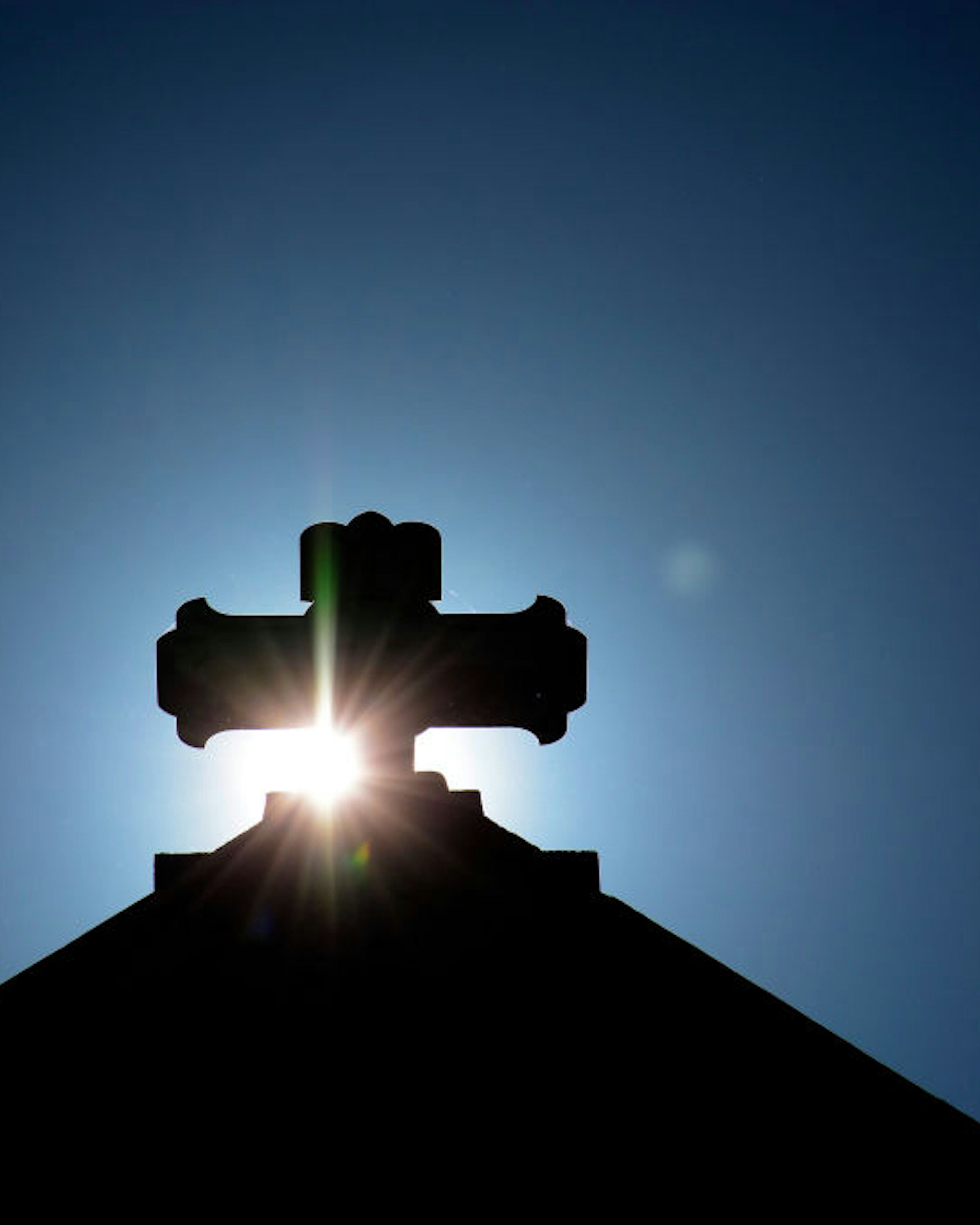 SANTA FE, NM - JULY 29, 2017: The morning sun rises behind a stone cross atop The Cathedral Basilica of St. Francis of Assisi, commonly known as Saint Francis Cathedral, in Santa Fe, New Mexico. Built between 1869 and 1886, the Roman Catholic Church is the mother church of the Archdiocese of Santa Fe. (Photo by Robert Alexander/Getty Images)