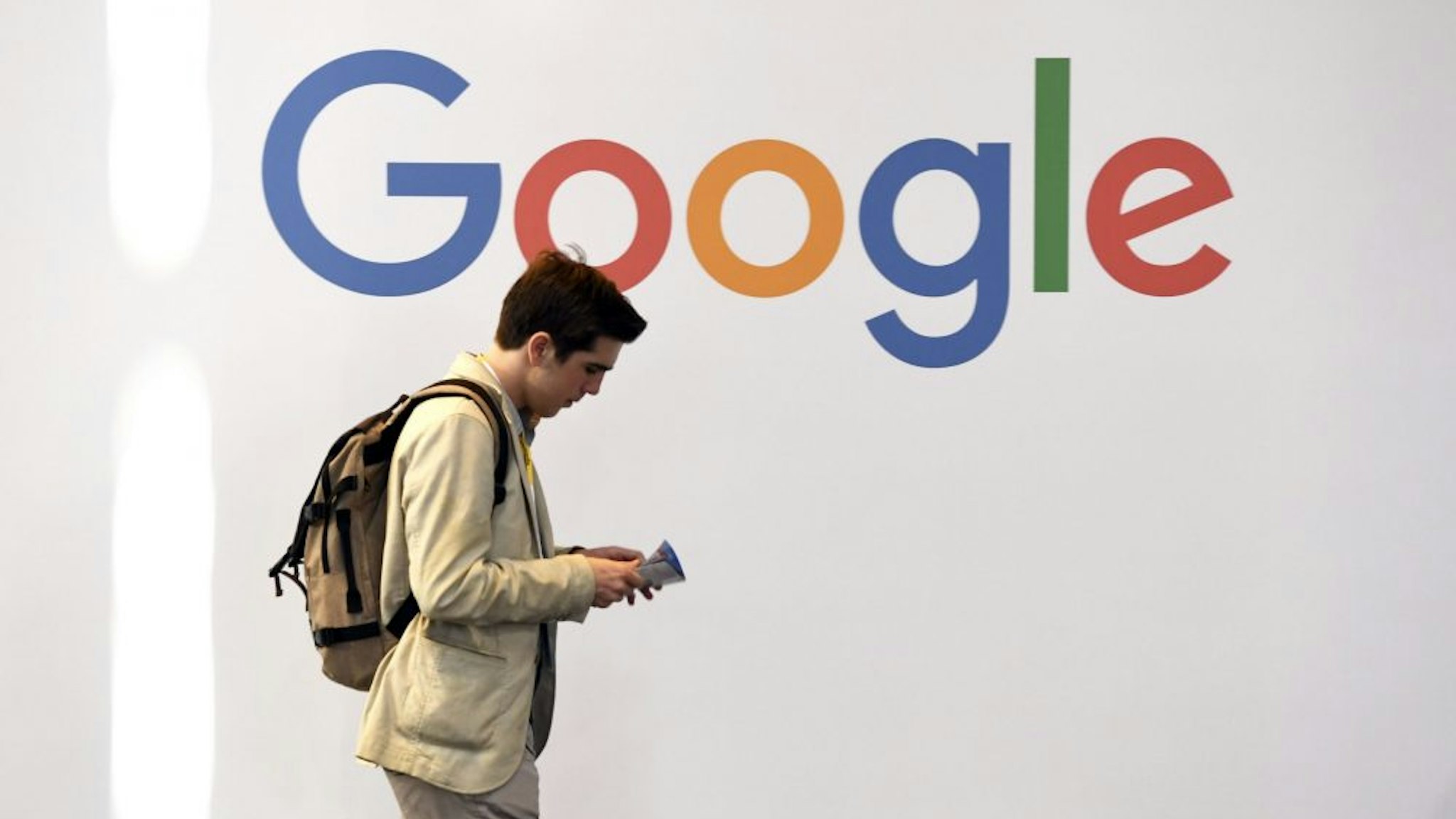 A man walks past the logo of the US multinational technology company Google during the VivaTech trade fair ( Viva Technology), on May 24, 2018 in Paris.