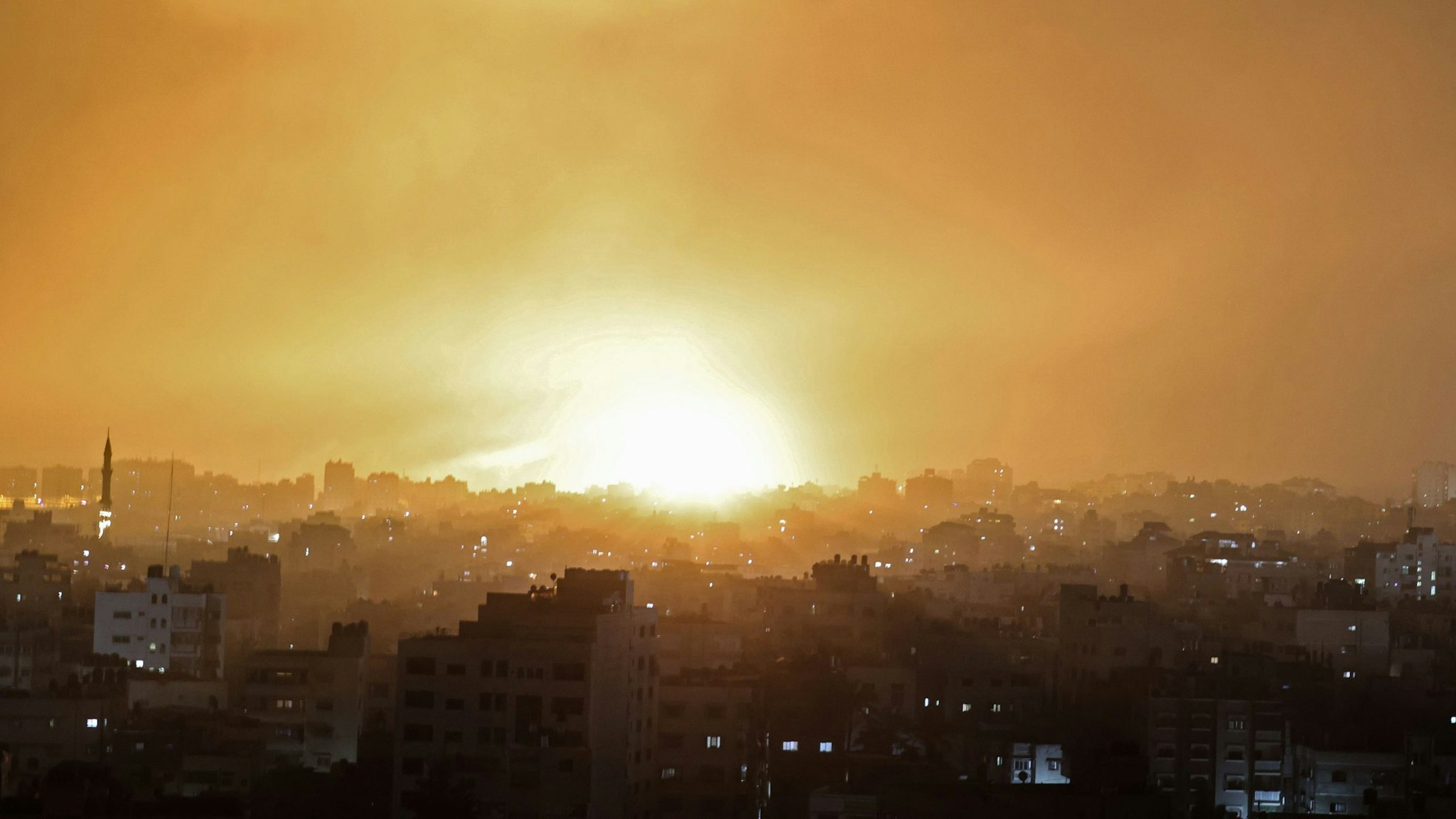TOPSHOT - An explosion lights the sky following an Israeli air strike on Beit Lahia in the northern Gaza Strip on May 14, 2021.