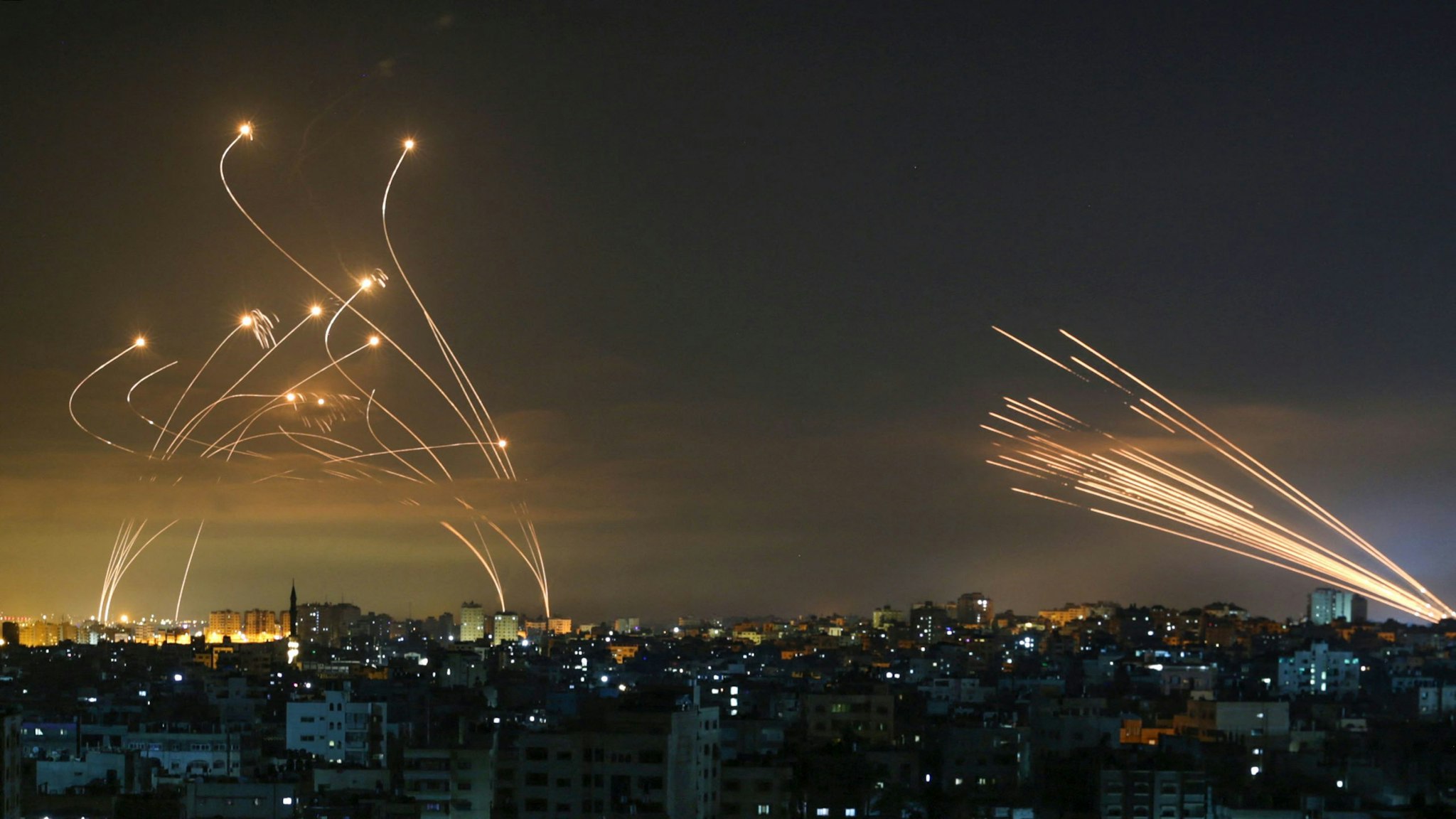 Rockets are seen in the night sky fired towards Israel from Beit Lahia in the northern Gaza Strip on May 14, 2021. - Israel bombarded Gaza with artillery and air strikes on Friday, May 14, in response to a new barrage of rocket fire from the Hamas-run enclave, but stopped short of a ground offensive in the conflict that has now claimed more than 100 Palestinian lives. As the violence intensified, Israel said it was carrying out an attack "in the Gaza Strip" although it later clarified there were no boots on the ground.