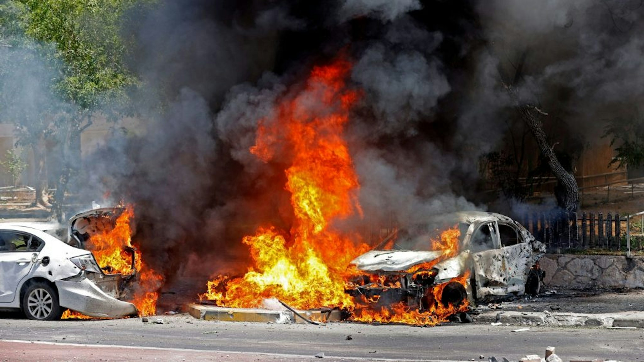 A picture taken on May 11, 2021 shows burning cars after a rocket launched from the Gaza Strip, controlled by the Palestinian Hamas movement, landed in the southern Israeli city of Ashkelon. - Israel and Hamas exchanged heavy fire, in a dramatic escalation between the bitter foes sparked by unrest at Jerusalem's flashpoint Al-Aqsa Mosque compound.