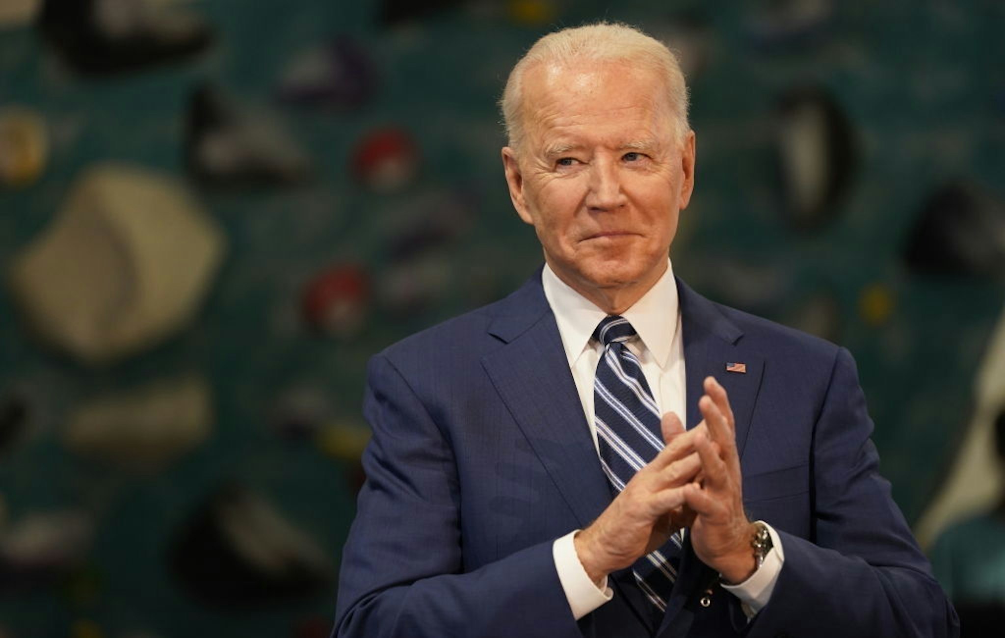 U.S. President Joe Biden applauds while Ralph Northam, governor of Virginia, not pictured, speaks at Sportrock Climbing Center during an event in Alexandria, Virginia, U.S., on Friday, May 28, 2021. Biden this week said he ordered the U.S. intelligence community to "redouble" its effort to determine where the coronavirus came from, after conflicting conclusions about whether its origins are natural or a lab accident. Photographer: Chris Kleponis/CNP/Bloomberg