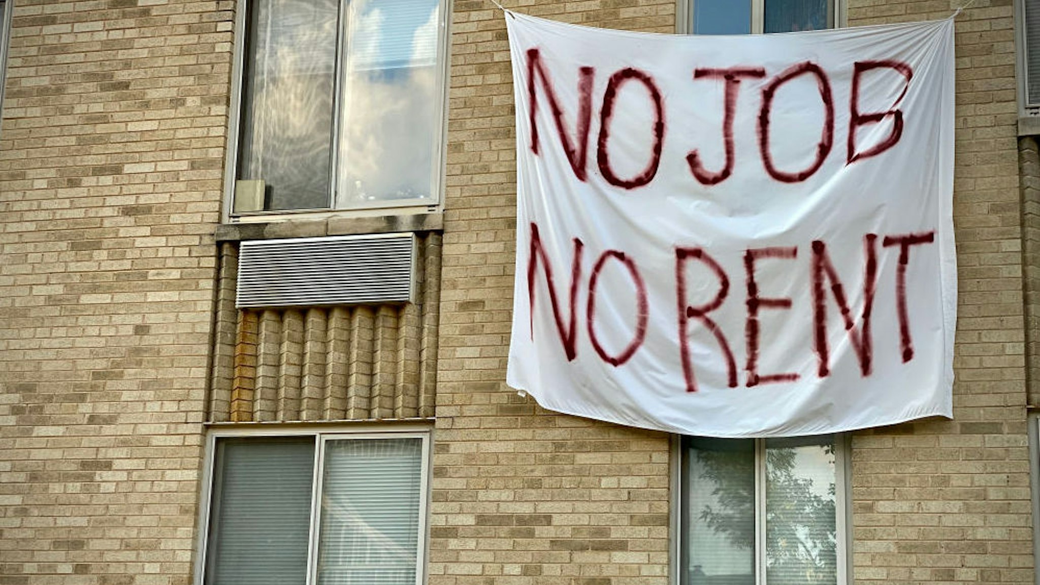 A banner against renters eviction reading no job, no rent is displayed on a controlled rent building in Washington, DC on August 9, 2020. - With double digit unemployment, disruption to businesses from social distancing rules, and persistent coronavirus spread, many Americans had been relying on relief measures approved earlier by Congress, but which mostly expired in July. One key Trump order promises to get $400 a week added to Americans' unemployment benefits, while two others offer some protection from evictions and relief for student loans.