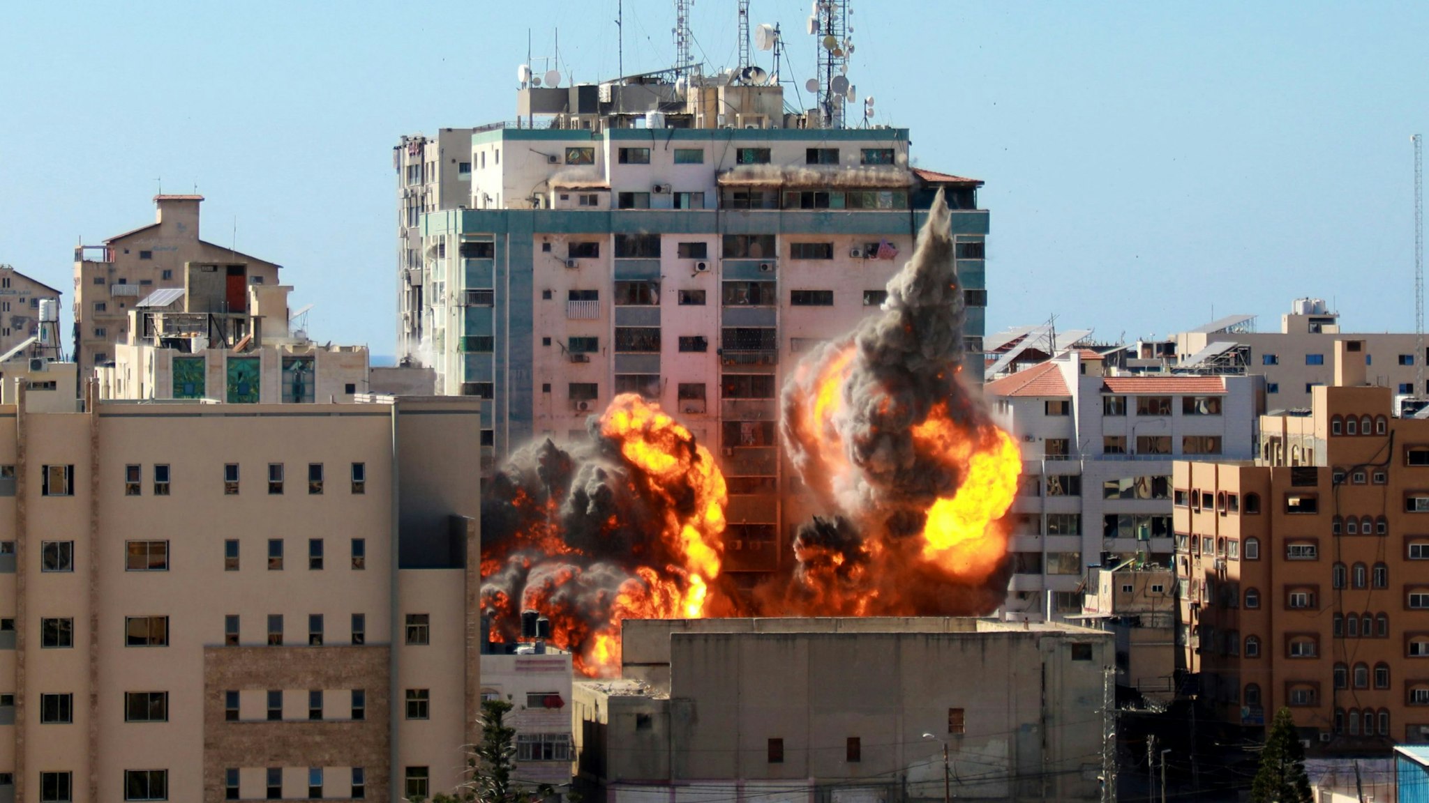 A ball of fire erupts from the Jala Tower as it is destroyed in an Israeli airstrike in Gaza city controlled by the Palestinian Hamas movement, on May 15, 2021. - Israeli air strikes pounded the Gaza Strip, killing 10 members of an extended family and demolishing a key media building, while Palestinian militants launched rockets in return amid violence in the West Bank. Israel's air force targeted the 13-floor Jala Tower housing Qatar-based Al-Jazeera television and the Associated Press news agency.