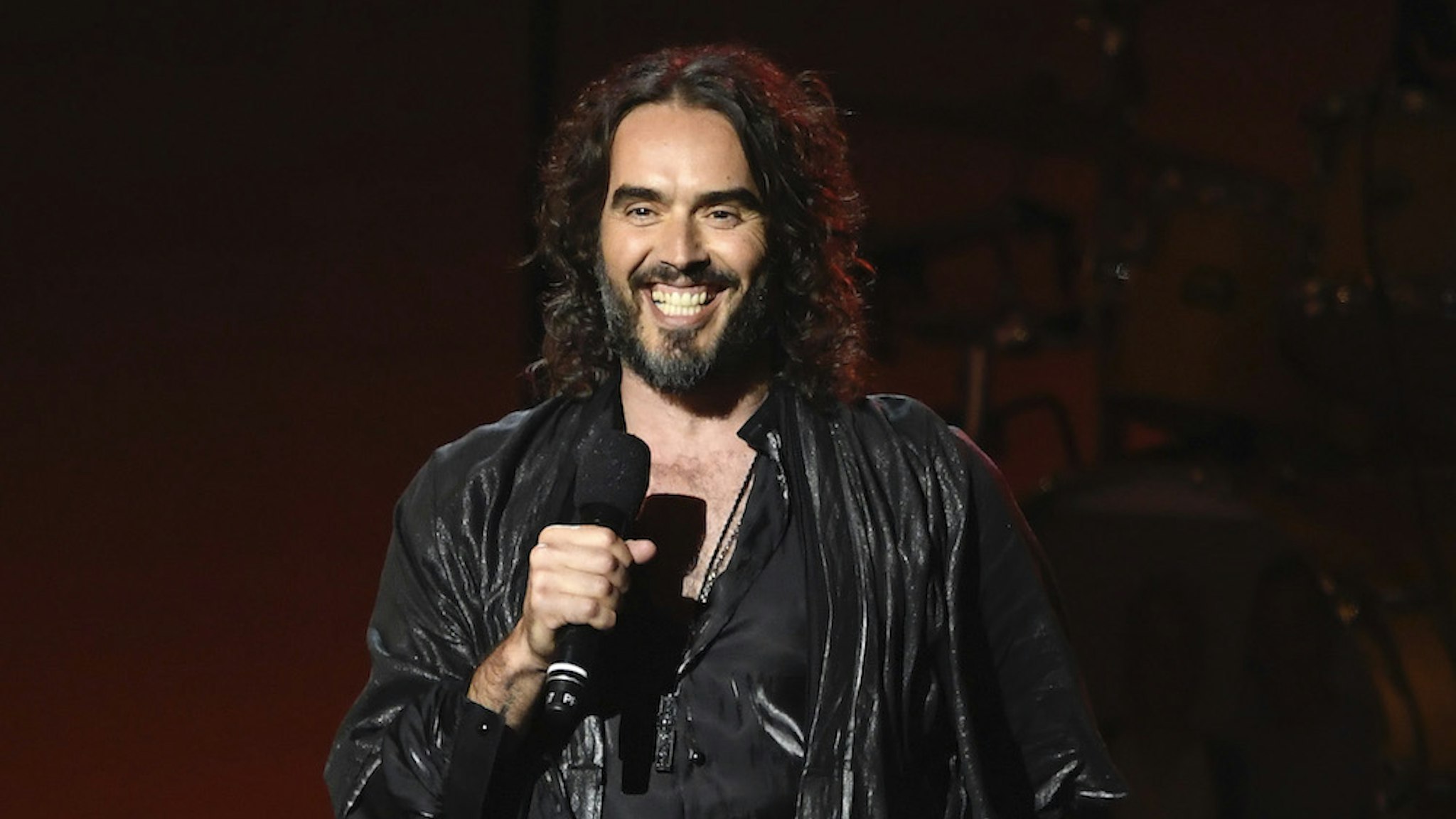LOS ANGELES, CALIFORNIA - JANUARY 24: (EDITORS NOTE: Retransmission with alternate crop.) Russell Brand speaks onstage during MusiCares Person of the Year honoring Aerosmith at West Hall at Los Angeles Convention Center on January 24, 2020 in Los Angeles, California. (Photo by Kevork Djansezian/Getty Images for The Recording Academy)