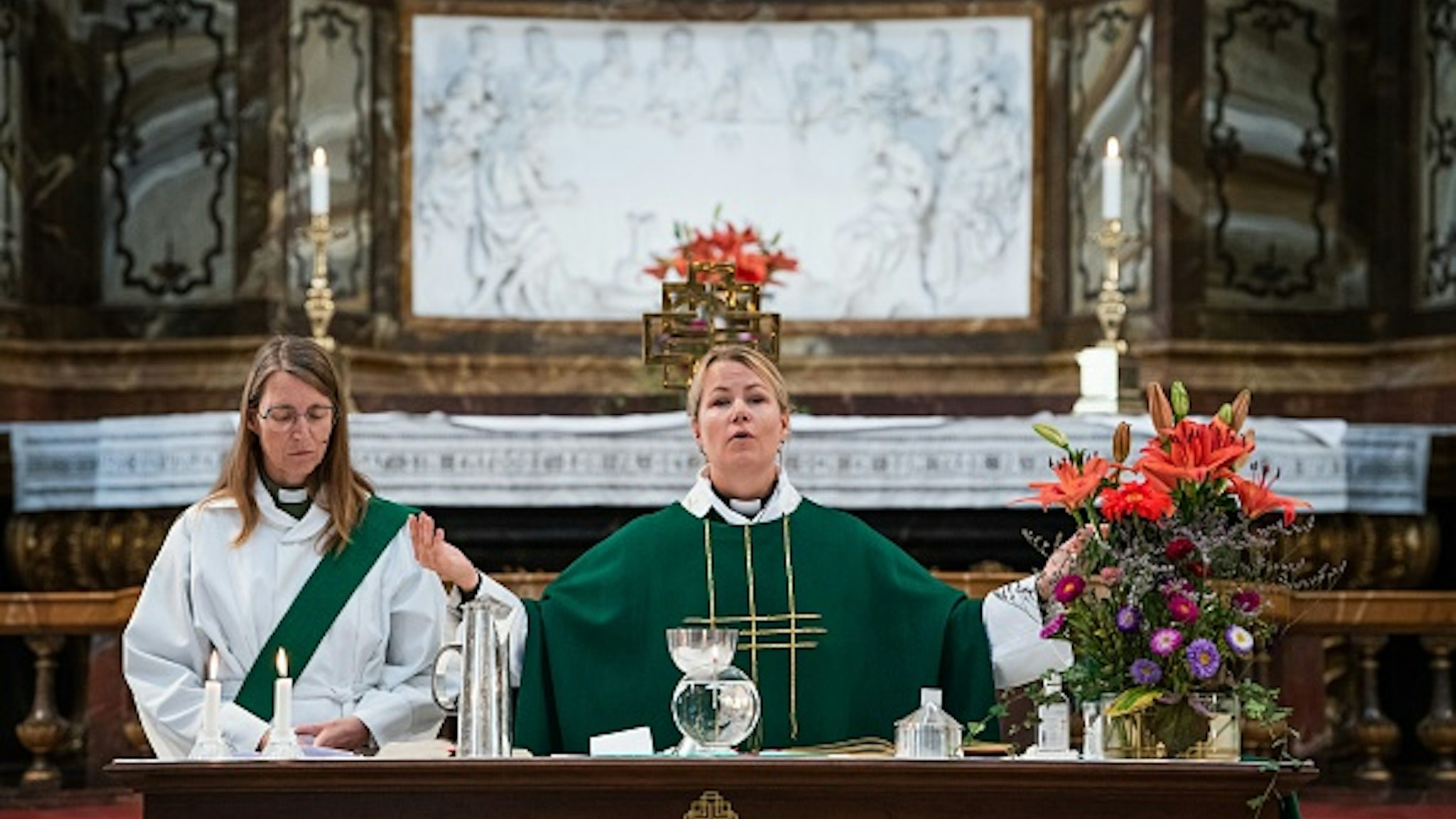 Priest Sandra Signarsdotter (R) and Deacon Ingrid El Qortobi gives the Sunday service at Gustaf Vasa Church in Odenplan, Stockholm on August 23, 2020. - In the Scandinavian country, often hailed as a champion of gender equality, the statistics are clear. As of July, 50.1 percent of priests are women and 49.9 percent are men.