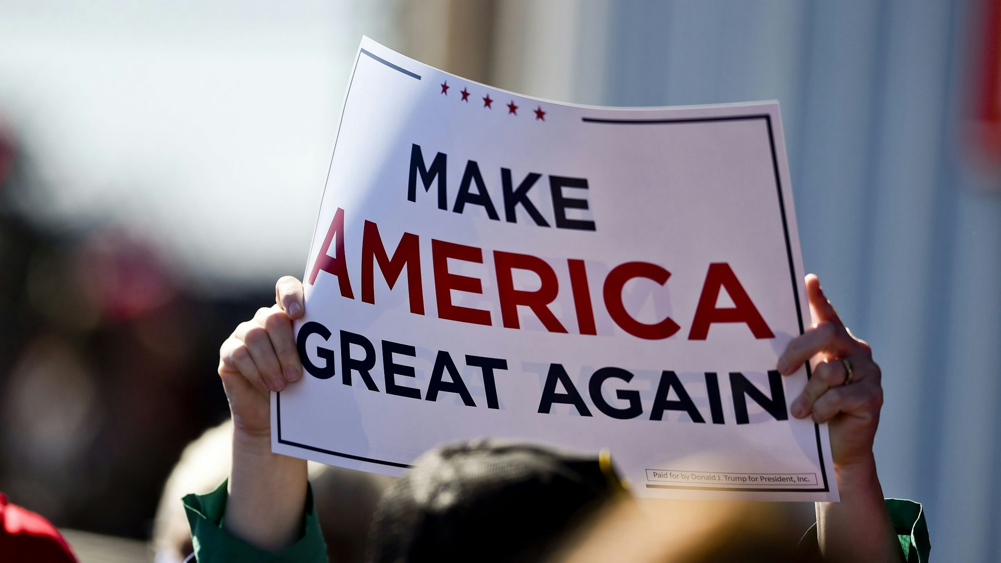 A supporter holds a "Make America Great Again" sign. At the Reading Regional Airport in Bern township Saturday October 17, 2020 where Vice President Mike Pence made a stop in Air Force 2 for a campaign rally.