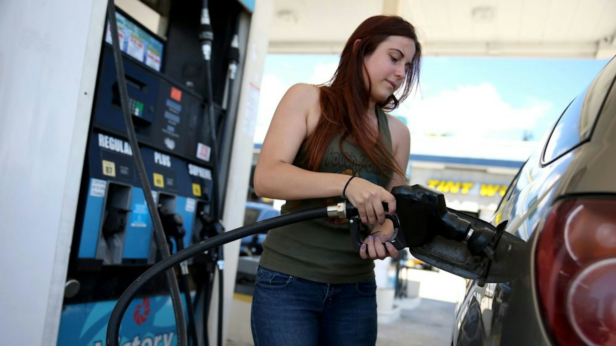 PEMBROKE PINES, FL - APRIL 21: Gabrielle Smith pumps gas at the Victory gas station on April 21, 2014 in Pembroke Pines, Florida. According to the Lundberg Survey the average price for a gallon of regular gas is now $3.69- the highest price since March of last year.