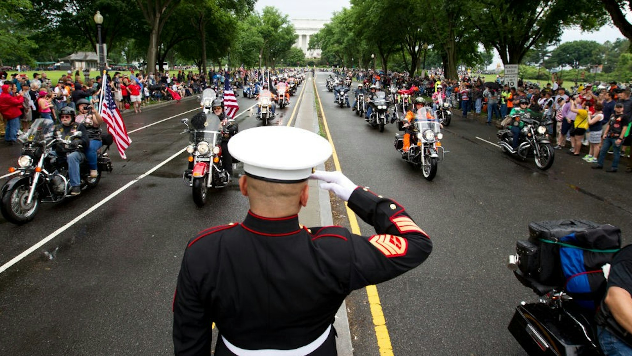 TOPSHOT - US Marine Tim Chambers salutes as participants in the Rolling Thunder annual motorcycle rally ride in Washington DC, on May 28, 2017. Motorcyclists are in Washington for the traditional annual Rolling Thunder ahead of Memorial Day, May 29. / AFP PHOTO / Jose Luis Magana (Photo credit should read