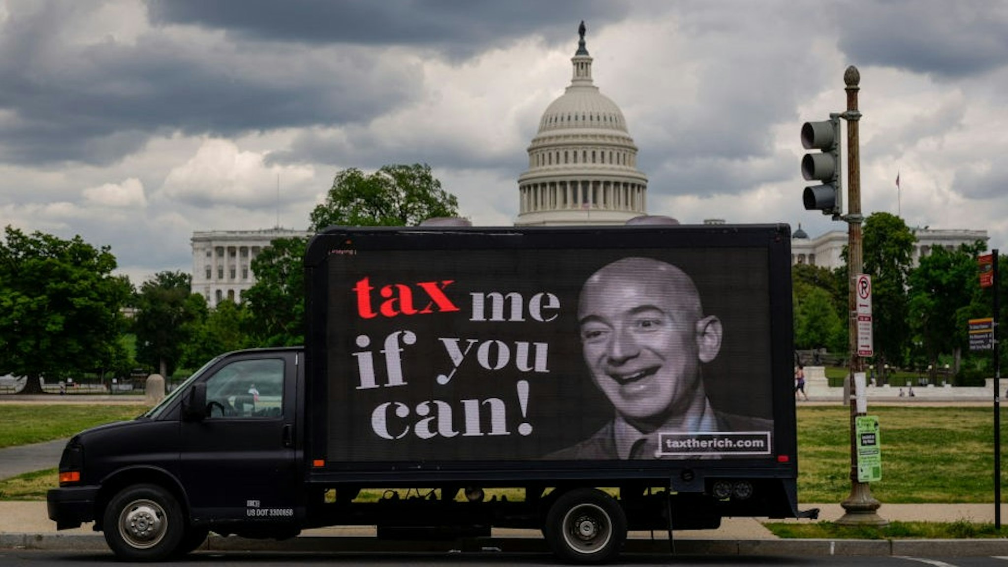 WASHINGTON, DC - MAY 17: A mobile billboard calling for higher taxes on the ultra-wealthy depicts an image of billionaire businessman Jeff Bezos, near the U.S. Capitol on May 17, 2021 in Washington, DC. Organized by the group "Patriotic Millionaires," the mobile billboards are rolling through Washington, DC and New York City on Monday to mark Tax Day, calling for higher taxes for wealthy Americans. (Photo by