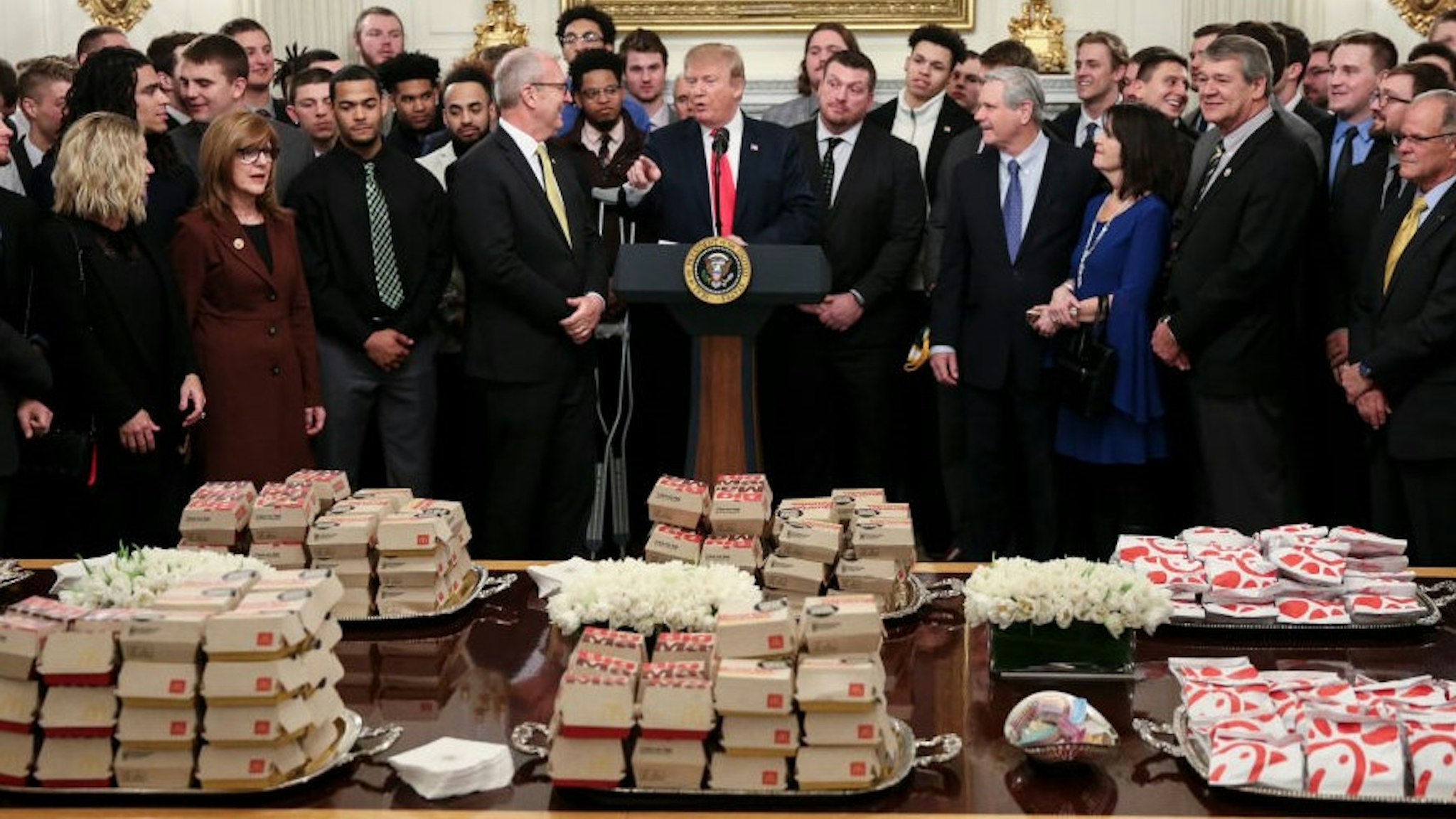 WASHINGTON, DC - MARCH 4: (AFP OUT) U.S. President Donald Trump speaks behind a table full of McDonald's hamburgers, Chick fil-a sandwiches and other fast food as he welcomes the 2018 Football Division I FCS champs North Dakota State Bison in the Diplomatic Room of the White House on March 4, 2019 in Washington, DC. (Photo by