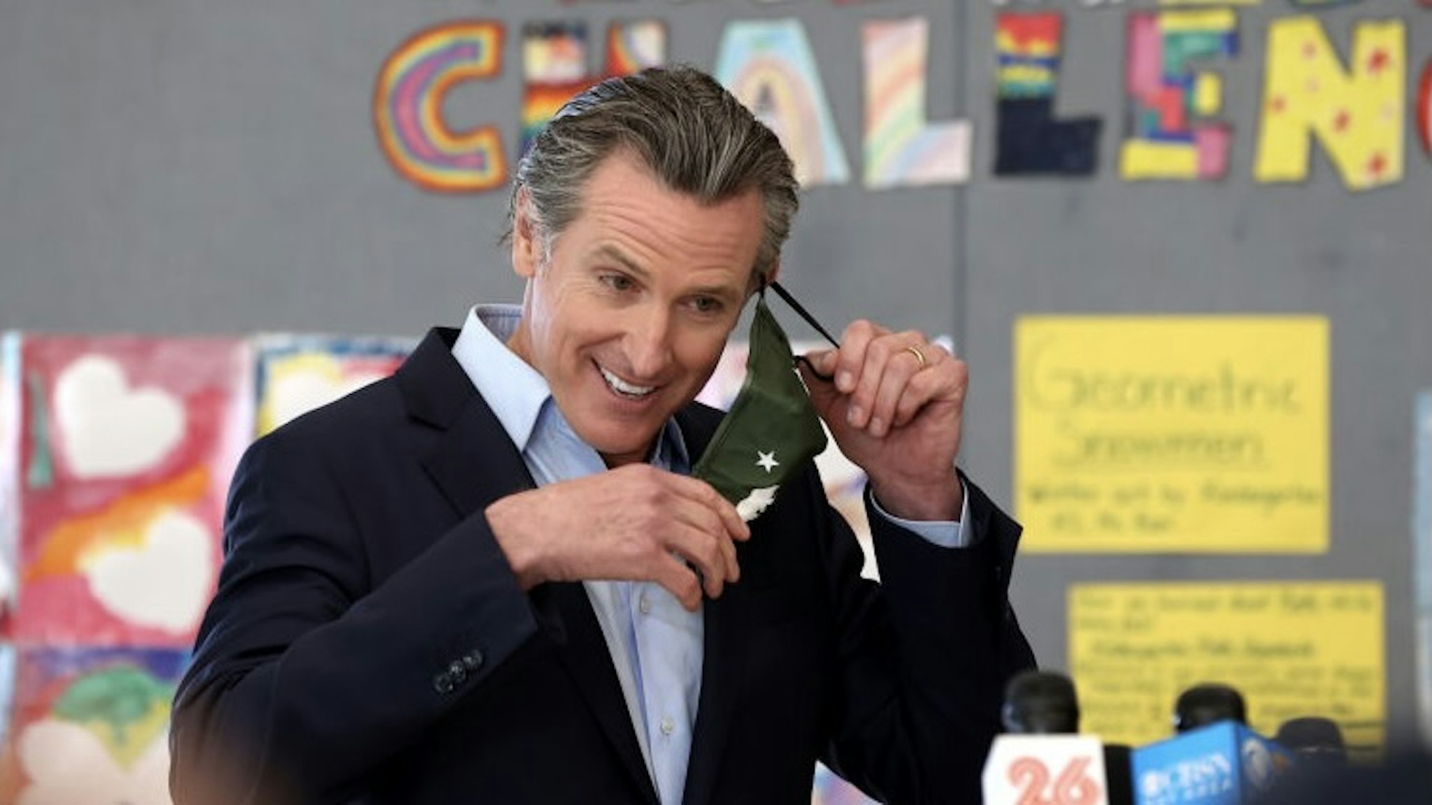 Governor Gavin Newsom Visits School To Highlight State's Reopening Efforts ALAMEDA, CALIFORNIA - MARCH 16: California Gov. Gavin Newsom removes his mask before speaking during a news conference after he toured the newly reopened Ruby Bridges Elementary School on March 16, 2021 in Alameda, California. Gov. Newsom is traveling throughout California to highlight the state's efforts to reopen schools and businesses as he faces the threat of recall. (Photo by Justin Sullivan/Getty Images) Justin Sullivan / Staff via Getty Images