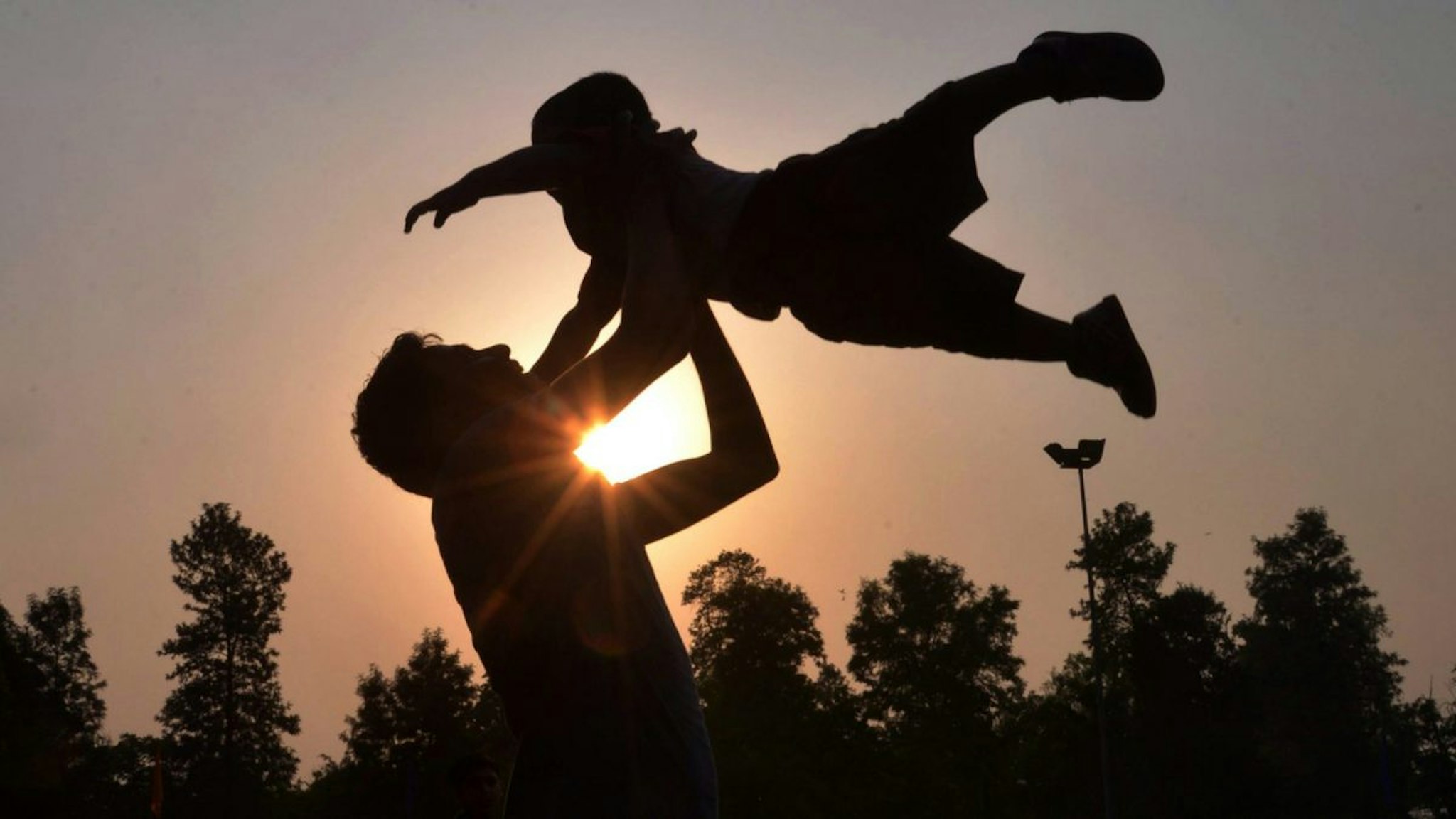 Indian father Shailesh throws up his son, Harish, at a park in Amritsar on June 19, 2016, on Father's Day, a day observed in many countries to celebrate fathers and fatherhood.