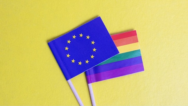 Small LGBT and EU flags on yellow background - stock photo Small LGBT and EU flags on yellow background close up Vera Aksionava via Getty Images