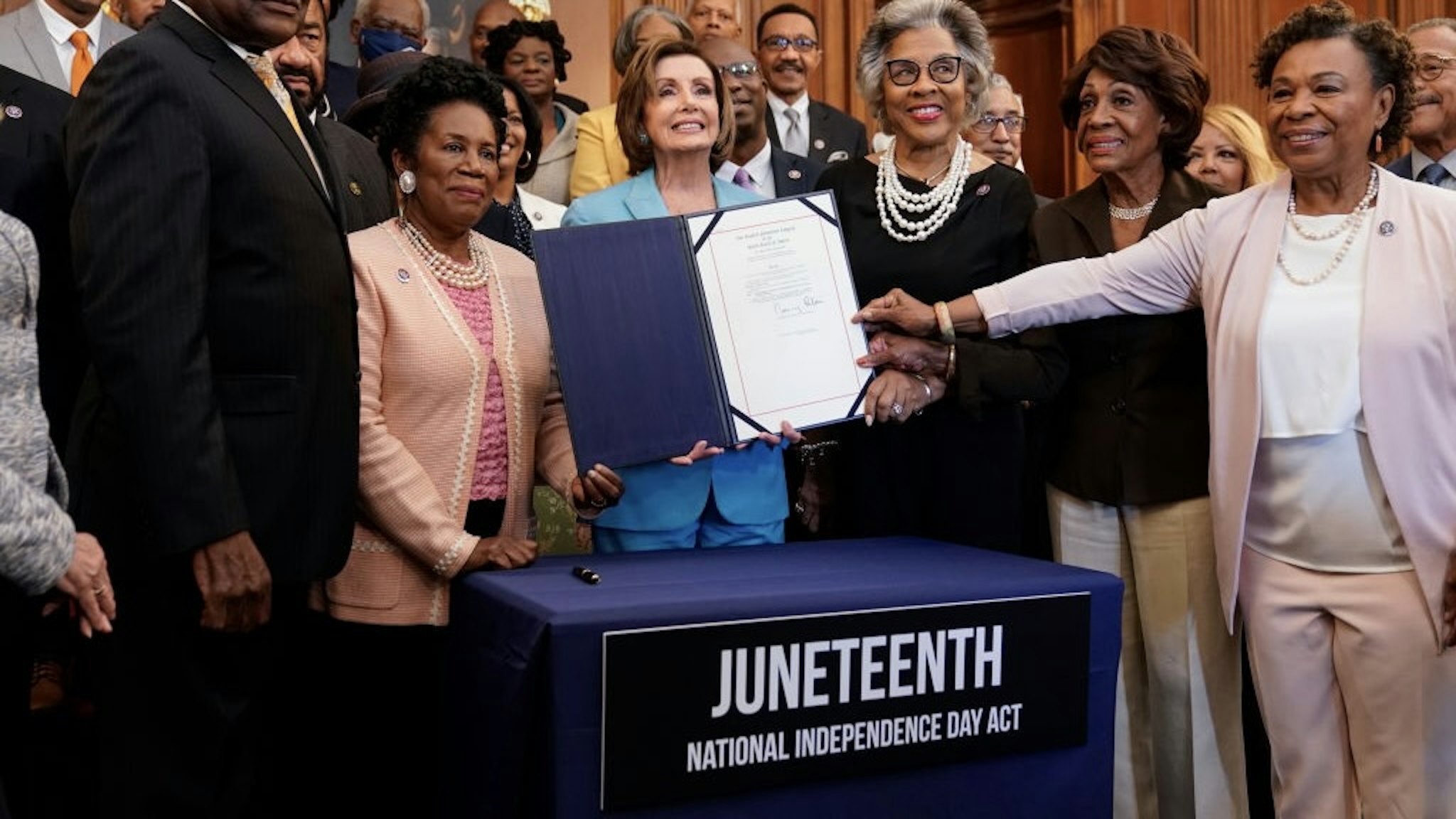 Speaker Pelosi Holds Bill Enrollment Event For Juneteenth National Independence Day Act WASHINGTON, DC - JUNE 17: Speaker of the House Nancy Pelosi (D-CA) holds a bill enrollment signing ceremony for the Juneteenth National Independence Day Act as members of the Congressional Black Caucus hold the bill on June 17, 2021 on Capitol Hill in Washington, DC. Juneteenth, celebrated on June 19th, commemorates the of the end of slavery in the United States and will be celebrated as a national holiday. (Photo by Joshua Roberts/Getty Images) Joshua Roberts / Stringer via Getty Images