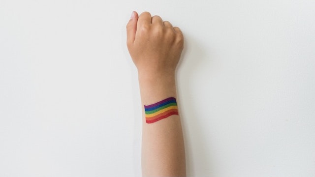 Raised child hand with rainbow LGBTQ pride flag tattoo - stock photo Raised child hand with rainbow LGBTQ pride flag tattoo. Movement symbol tataks via Getty Images