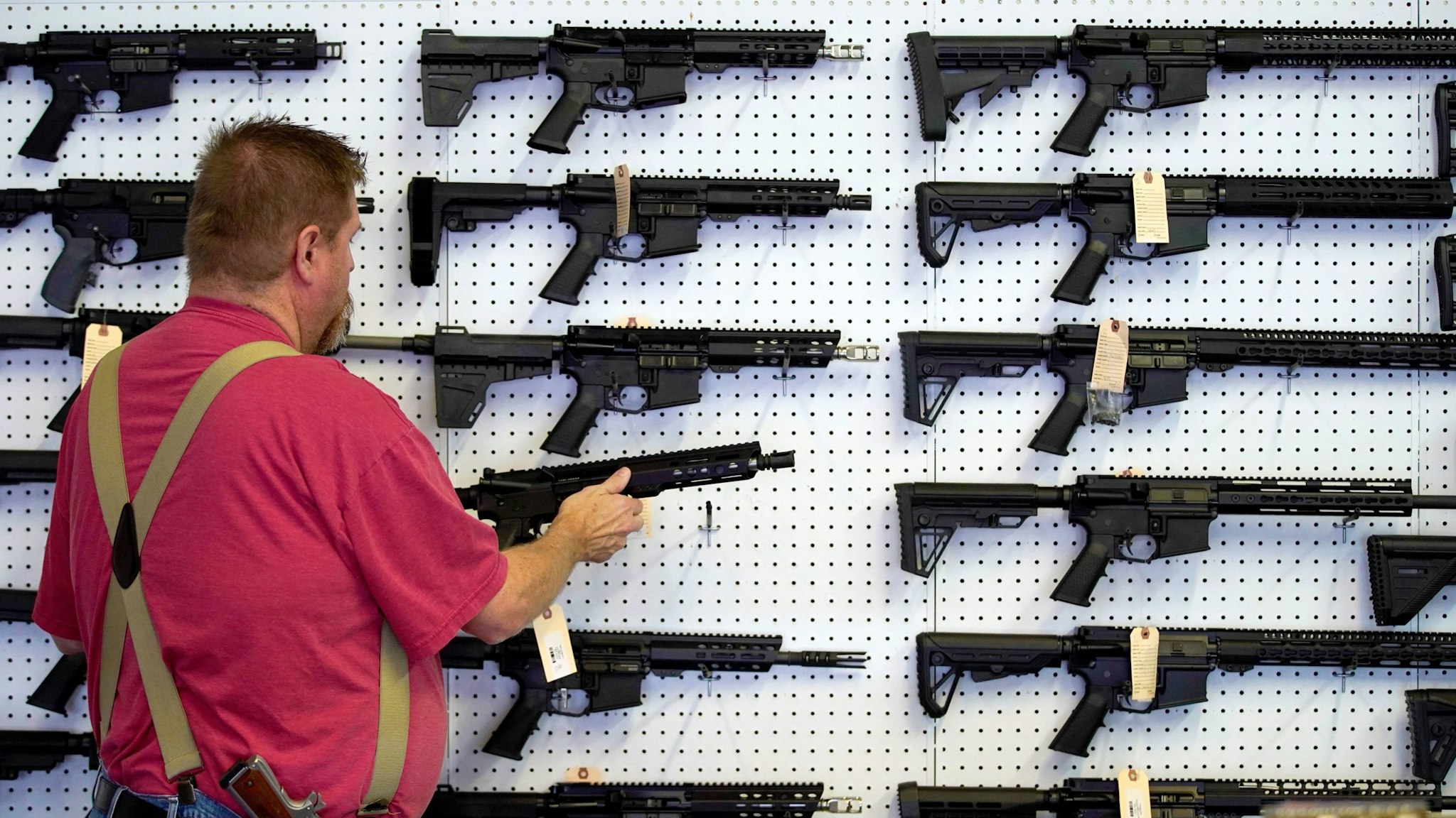 A worker restocks AR-15 guns at Davidson Defense in Orem, Utah on March 20, 2020. - Gun stores in the US are reporting a surge in sales of firearms as coronavirus fears trigger personal safety concerns.