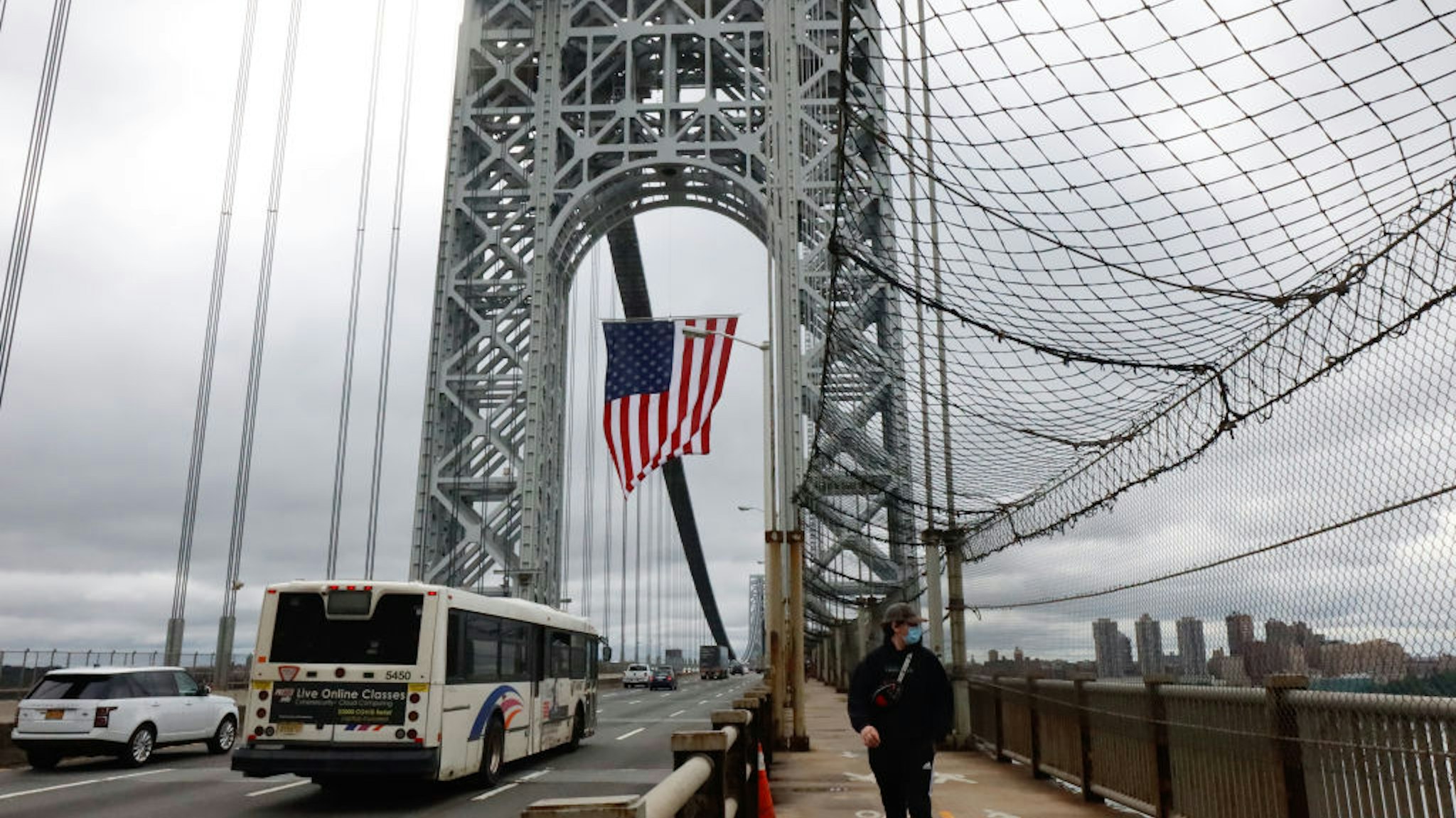 FT. LEE, NJ - MAY 31: The George Washington Bridge hangs its 60 x 90-foot American flag from the New Jersey side tower to mark Memorial Day as an NJ Transit bus heads to New York City on May 31, 2021 in Ft. Lee, New Jersey.