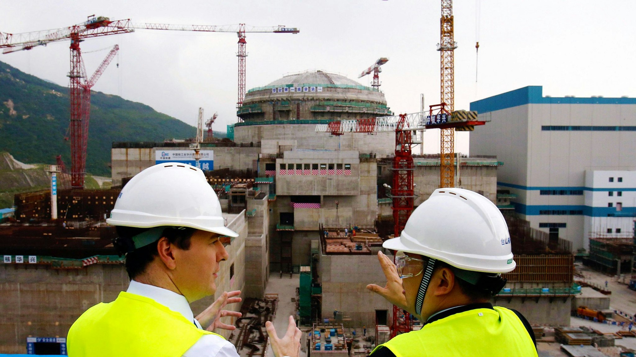 TAISHAN, CHINA - OCTOBER 17: British Chancellor of the Exchequer George Osborne talks with Guo Liming of Taishan Nuclear Power Joint Venture Co Ltd (R) as he tours a nuclear reactor under construction at Taishan power plant on October 17, 2013 in Taishan, Guangdong province, China. Chancellor George Osborne has announced on the last day of his trade visit that future generations of British nuclear power plants will be funded, developed and managed in joint UK and Chinese partnership agreements, with China expected to hold majority stakes.