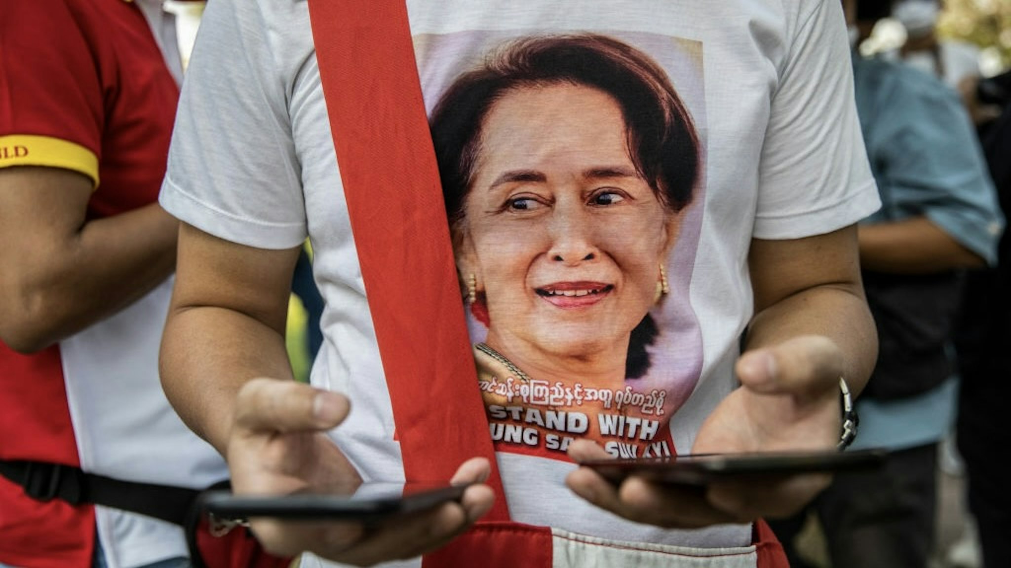 Myanmar Nationals Protest Outside UN Building BANGKOK, THAILAND - FEBRUARY 03: A Myanmar anti-coup protester wears an Aung San Suu Kyi shirt at a rally in front of the United Nations on February 03, 2021 in Bangkok, Thailand. Burmese migrants in Thailand gathered outside the United Nations headquarters for Southeast Asia as they continued to protest the Myanmar military's coup d'etat on Monday. The Tatmadaw, the country's military, suspended the government and arrested several figures including de-facto leader Aung San Suu Kyi, citing election fraud. (Photo by Lauren DeCicca/Getty Images) Lauren DeCicca / Stringer via Getty Images