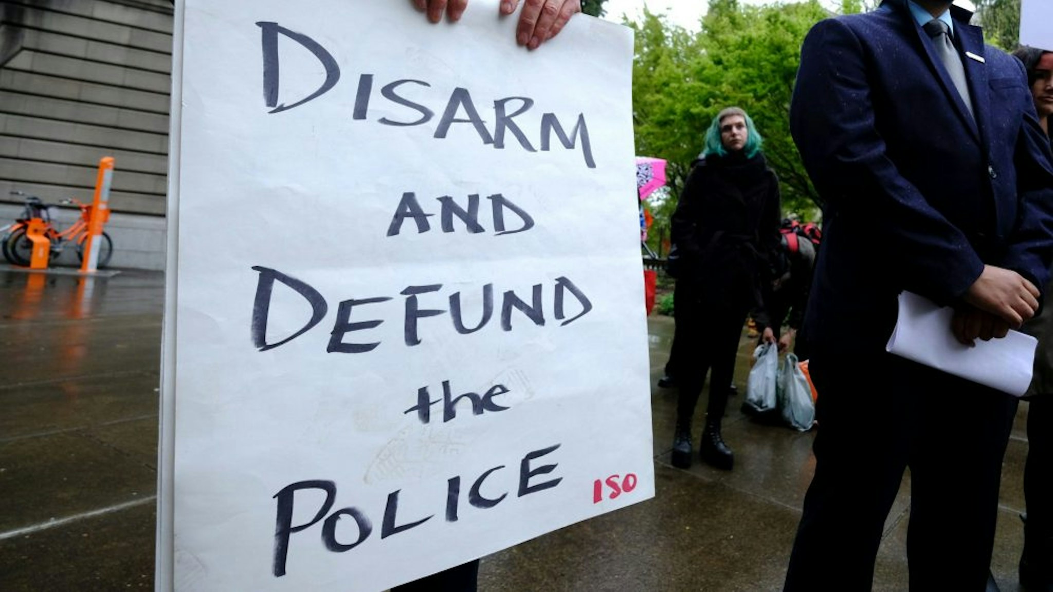 PORTLAND, USA - APRIL 11: A protester holds a sign reading "Disarm And Defund The Police" during a protest against fatal police shootings in Portland, Oregon, United States on April 11, 2018. John Andrew Elifritz, 48, was fatally shot by police after he reportedly fled from a stolen car and burst into a homeless shelter at the start of an alcoholics anonymous meeting last Saturday.