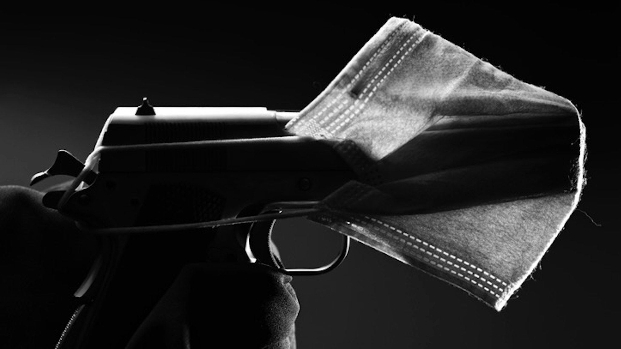 Health weaponized - stock photo A side shot of a face mask covering a gun representing how the current pandemic us being used to further some ambitions Images By Tenyo via Getty Images