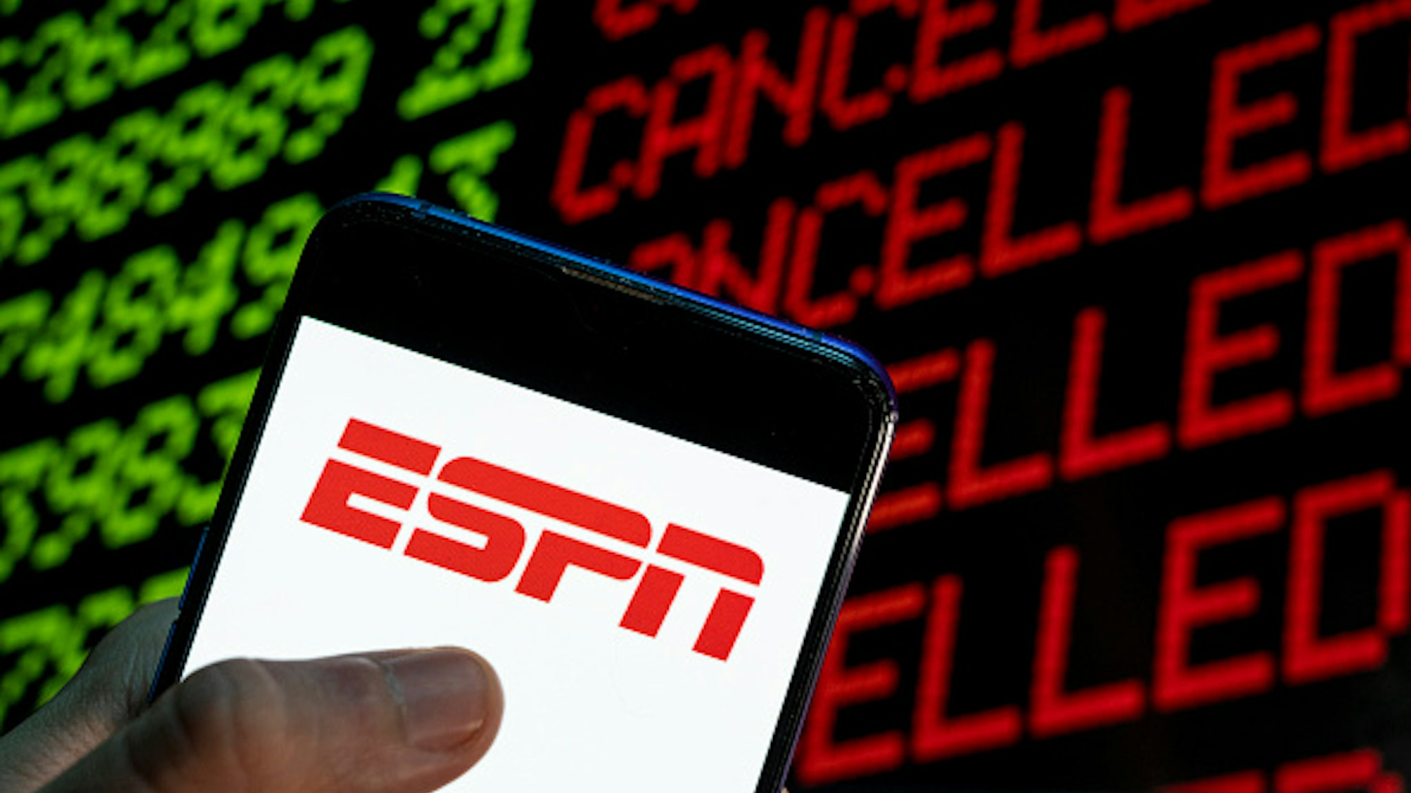 CHINA - 2021/04/24: In this photo illustration the American sports television channel ESPN logo is seen on an Android mobile device with the word cancelled on a computer screen.