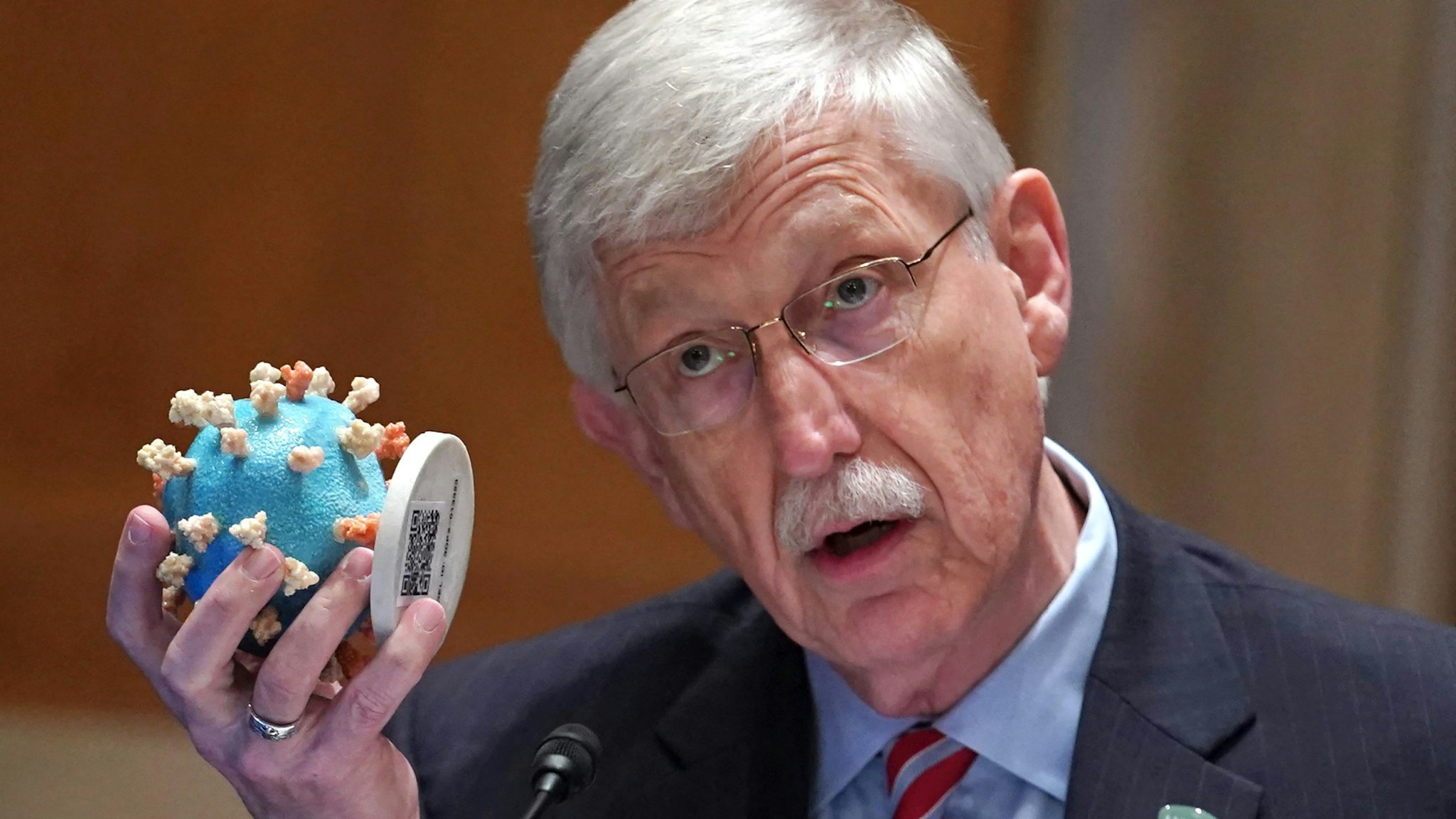 NIH Director Fr. Francis Collins holds up a model of the coronavirus as he testifies before a hearing looking into the budget estimates for National Institute of Health (NIH) and the state of medical research on Capitol Hill in Washington, DC on May 26, 2021.