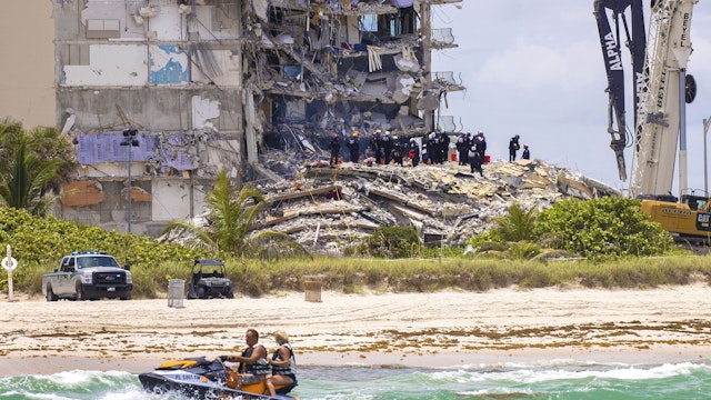 SURFSIDE, FLORIDA - JUNE 26: Members of the South Florida Urban Search and Rescue team look for possible survivors in the partially collapsed 12-story Champlain Towers South condo building on June 26, 2021 in Surfside, Florida. Over 150 people are being reported as missing as search-and-rescue efforts continue with rescue crews from across Miami-Dade and Broward counties.