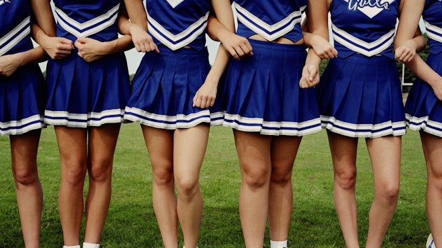 Cheerleaders arm in arm, lower body - stock photo