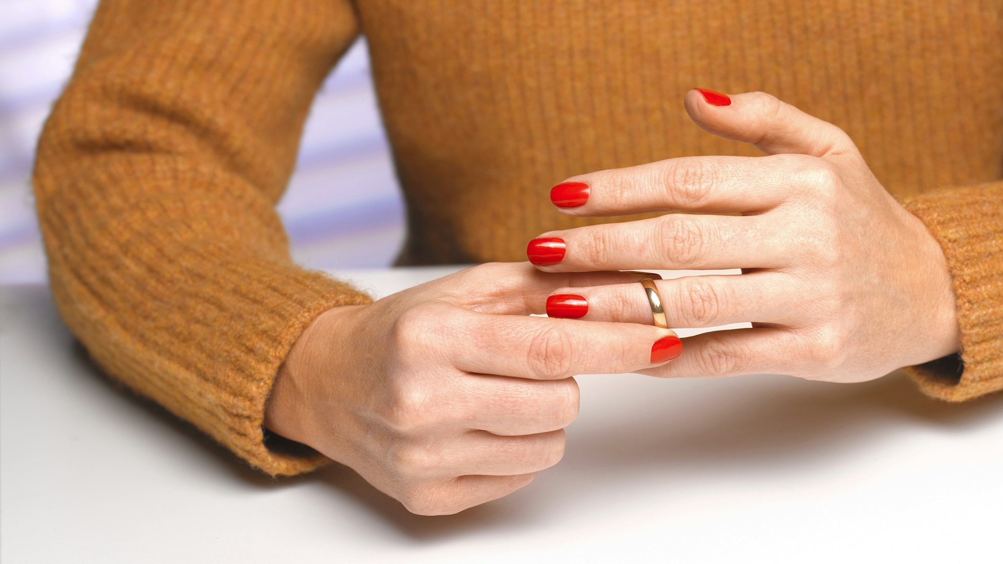 Divorced woman taking off wedding ring - stock photo