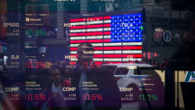 Monitors display stock market information as pedestrians are reflected in a window at the Nasdaq MarketSite in the Times Square area of New York, U.S., on Friday, April 26, 2019. U.S. stocks edged higher on better-than-forecast earnings while Treasury yields fell after data signaled tepid inflation in the first quarter. Photographer: Michael Nagle/Bloomberg via Getty Images