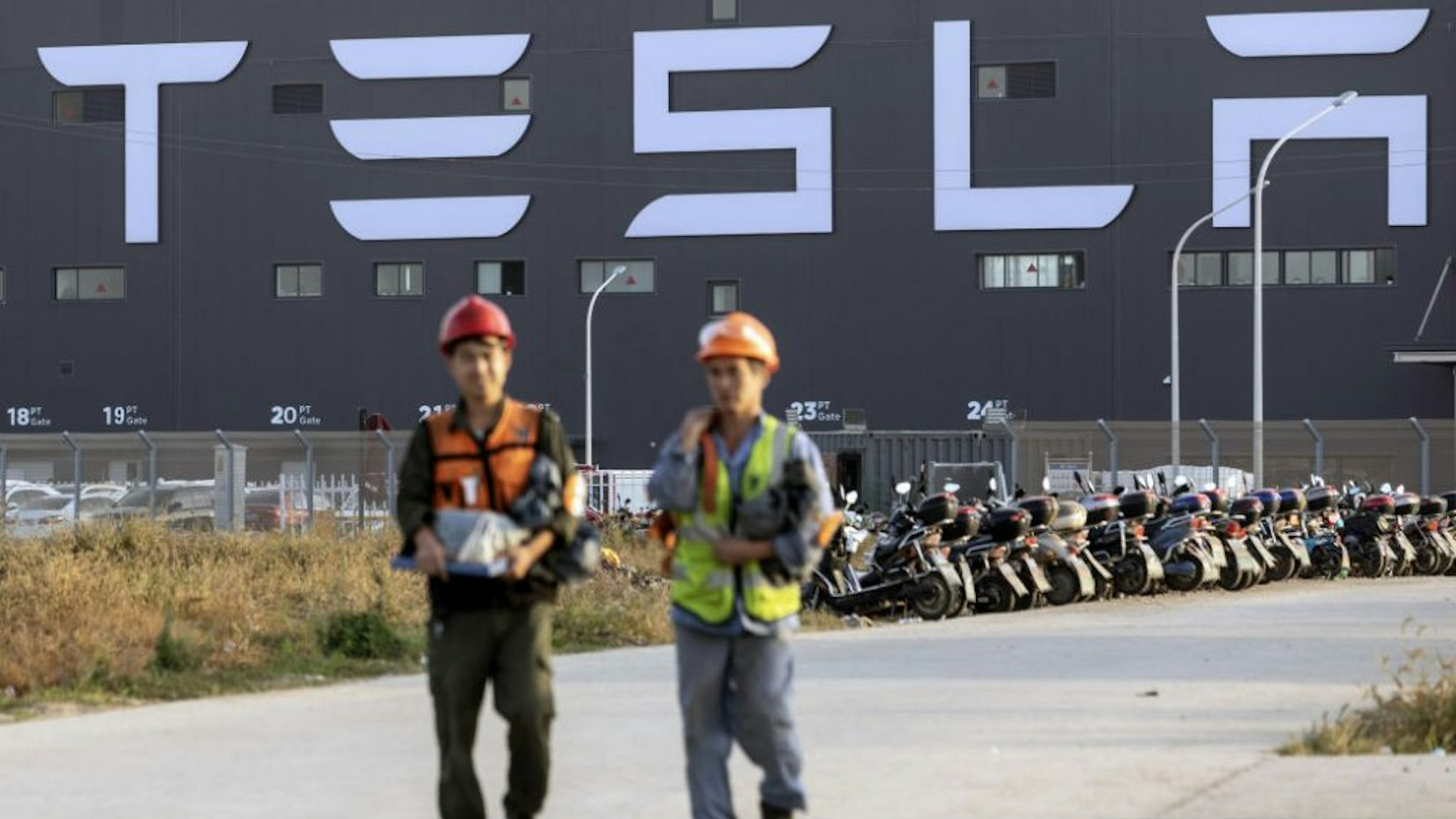 Workers walk outside the Tesla Inc. Gigafactory in Shanghai, China, on Friday, Nov. 1, 2019. After starting construction this year, Teslas new factory is already producing electric vehicles on a trial basis.