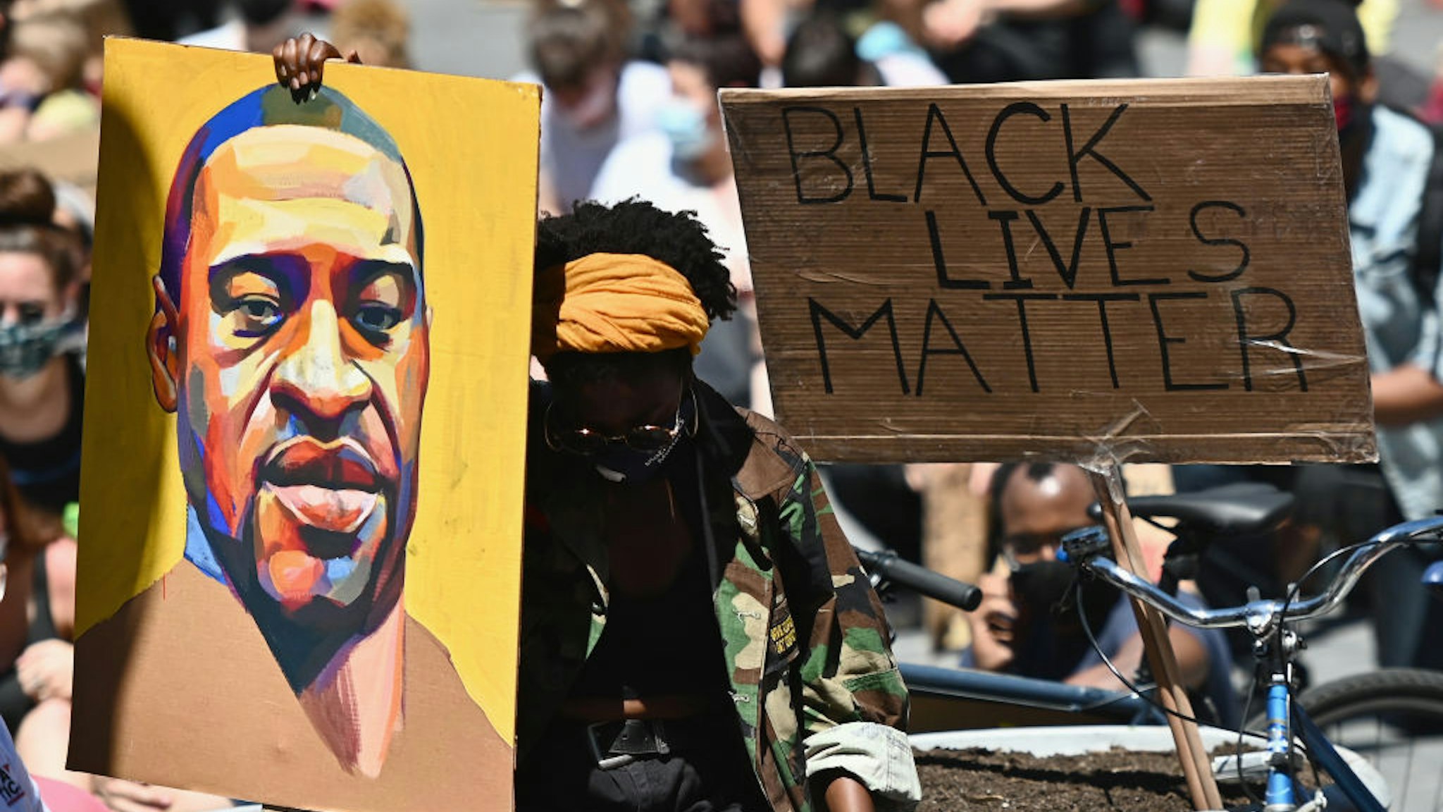 TOPSHOT - Protesters hold up signs during a "Black Lives Matter" protest in front of Borough Hall on June 8, 2020 in New York City. - On May 25, 2020, Floyd, a 46-year-old black man suspected of passing a counterfeit $20 bill, died in Minneapolis after Derek Chauvin, a white police officer, pressed his knee to Floyd's neck for almost nine minutes. (Photo by Angela Weiss / AFP) (Photo by ANGELA WEISS/AFP via Getty Images)