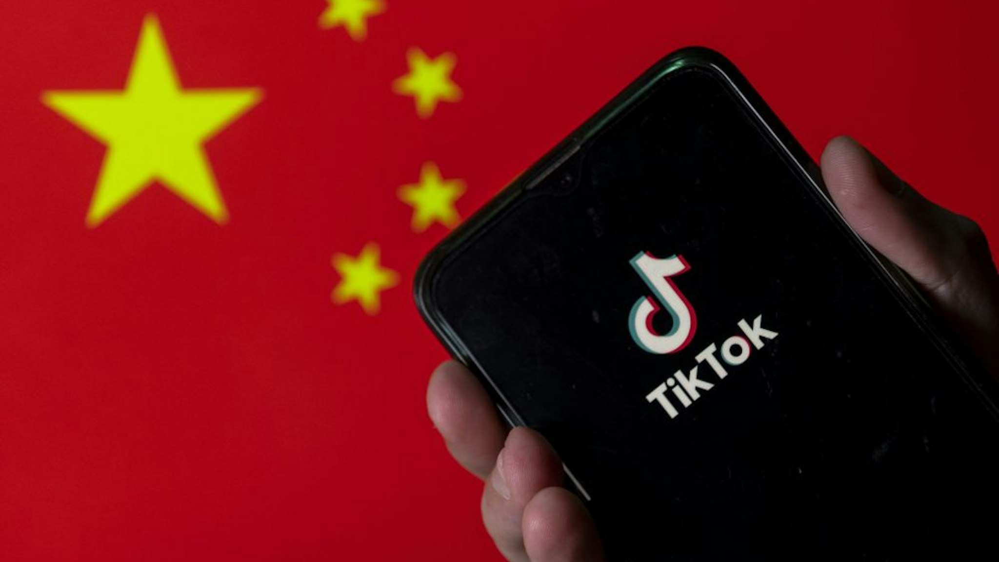 CHINA - 2020/08/11: In this photo illustration the Chinese video-sharing social networking service company, TikTok logo is seen on an Android mobile device with People's Republic of China flag in the background.