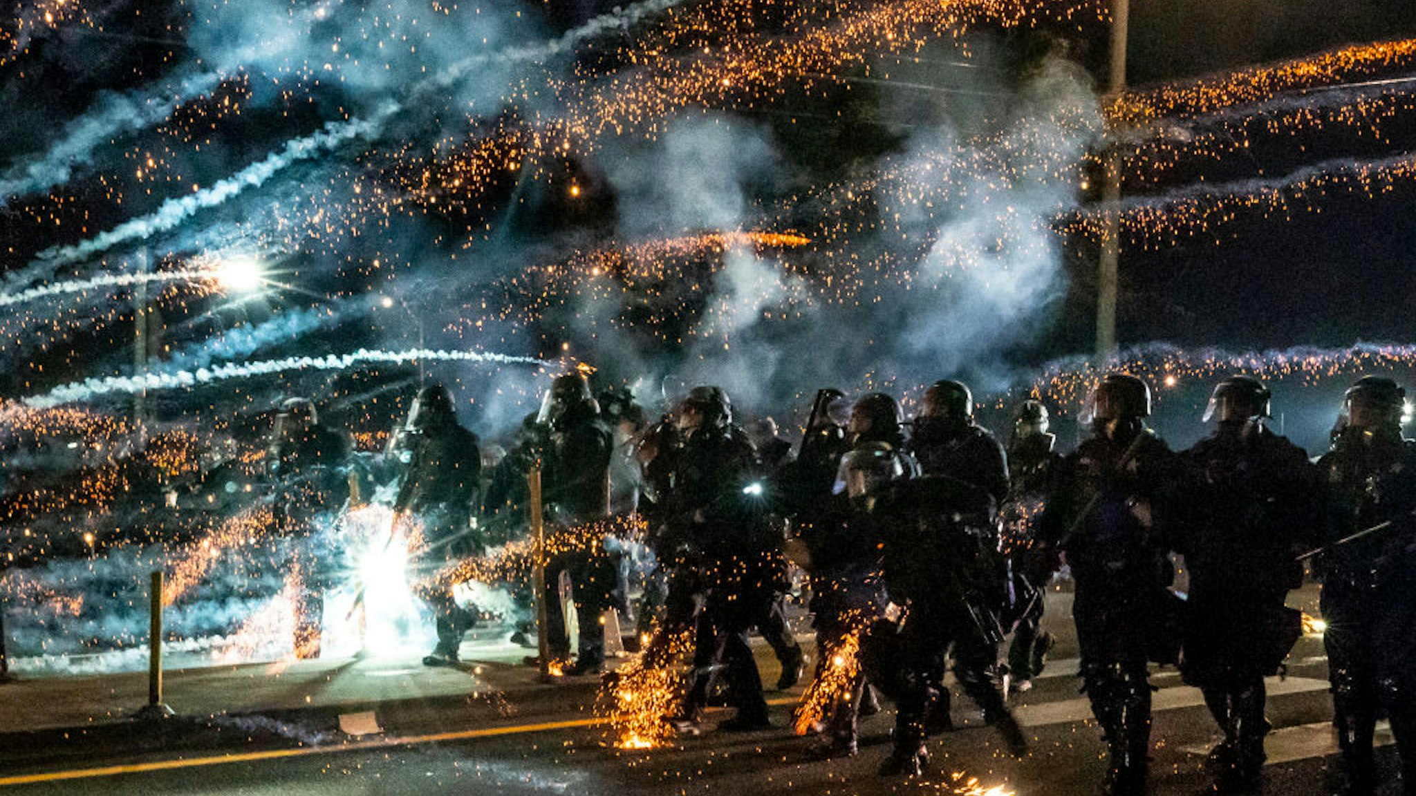 PORTLAND, OREGON - SEPTEMBER 5: Oregon State Troopers and Portland police advance through tear gas and fire works while dispersing a protest against police brutality and racial injustice on September 5, 2020 in Portland, Oregon. Portland has seen nightly protests for the past 100 days following the death of George Floyd in police custody. (Photo by Nathan Howard/Getty Images)