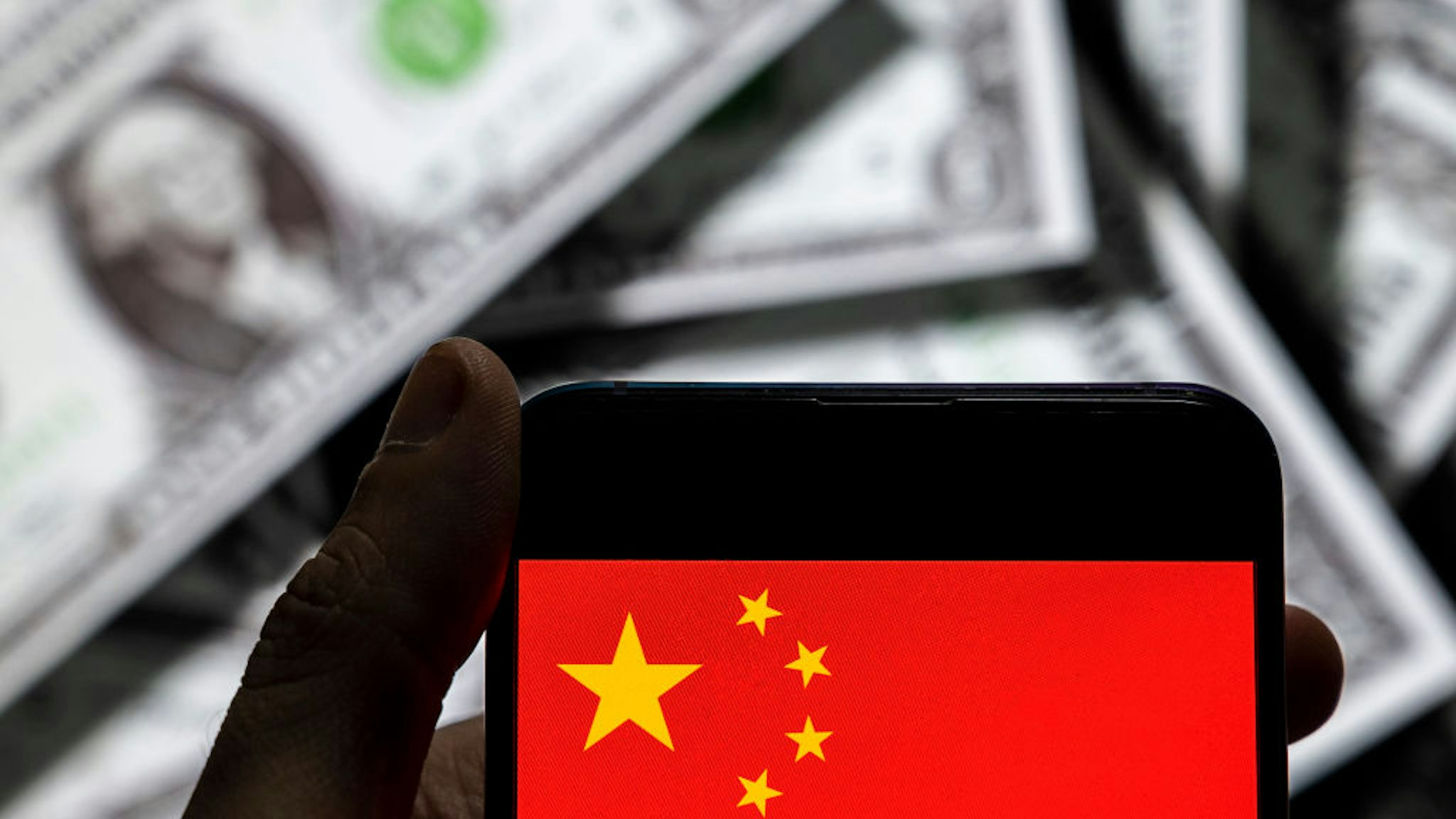 In this photo illustration the People's Republic of China flag logo seen on an Android mobile device screen with the currency of the United States dollar icon, $ icon symbol in the background.