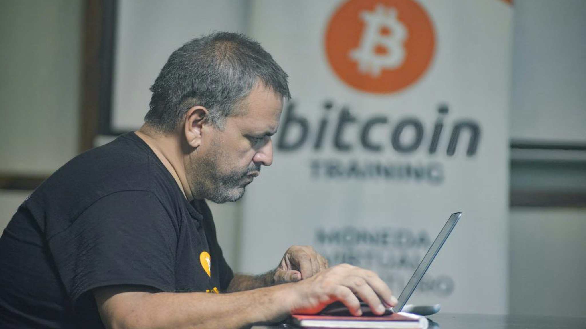 CHILTUIPAN, LA LIBERTAD, EL SALVADOR - 2021/06/07: A man works on a laptop at a Bitcoin training facility. Salvadoran President Nayib Bukele has announced that he will propose a law to the Congress, where his party controls a majority, for Bitcoin to become legal tender. El Salvador would become the first country in the world to accept a cryptocurrency as a legal tender.