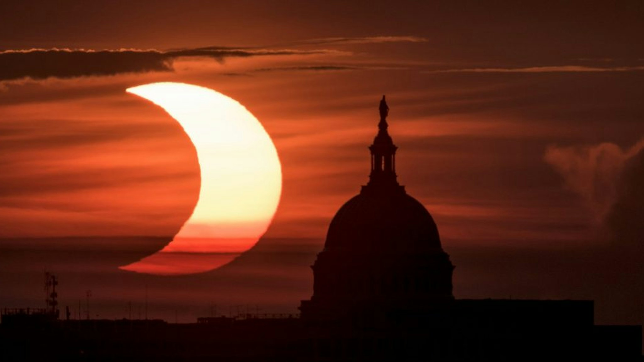 ARLINGTON, VIRGINIA - JUNE 10: In this handout image provided by NASA, a partial solar eclipse is seen as the sun rises behind the Capitol Building on June 10, 2021 in Arlington, Virginia. Northeast states in the U.S. will see a rare eclipsed sunrise, while in other parts of the Northern Hemisphere, this annular eclipse will be seen as a visible thin outer ring of the sun's disk that is not completely covered by the smaller dark disk of the moon, a so-called "ring of fire".