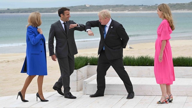 CARBIS BAY, CORNWALL - JUNE 11: Prime Minister of United Kingdom, Boris Johnson, greets President of France, Emmanuel Macron with an elbow bump as Carrie Johnson and Brigitte Macron, look on, during the Leaders official welcome and family photo during the G7 Summit In Carbis Bay, on June 11, 2021 in Carbis Bay, Cornwall. UK Prime Minister, Boris Johnson, hosts leaders from the USA, Japan, Germany, France, Italy and Canada at the G7 Summit. This year the UK has invited India, South Africa, and South Korea to attend the Leaders' Summit as guest countries as well as the EU.