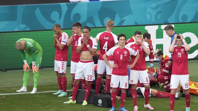 Denmark's players react as paramedics attend to Denmark's midfielder Christian Eriksen after he collapsed on the pitch during the UEFA EURO 2020 Group B football match between Denmark and Finland at the Parken Stadium in Copenhagen on June 12, 2021. - Denmark OUT