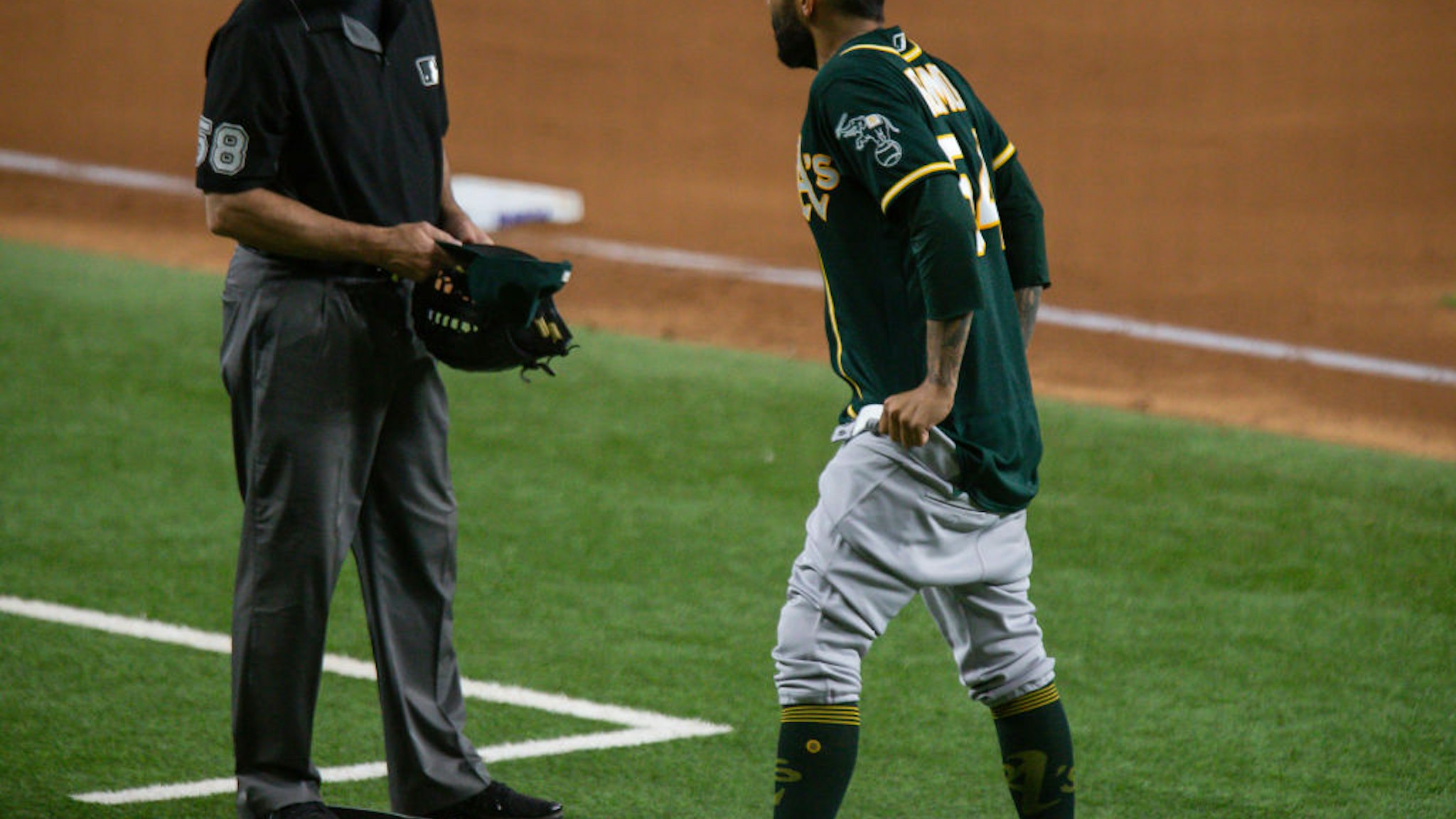ARLINGTON, TX - JUNE 22: Oakland Athletics Pitcher Sergio Romo (54) gives third base umpire Dan Iassogna his hat, glove, and belt to check and pulls down his pants during the Texas Rangers game versus the Oakland Athletics on Jun 22nd, 2021, at Globe Life Field in Arlington, TX. (Photo by Aric Becker/Icon Sportswire via Getty Images)