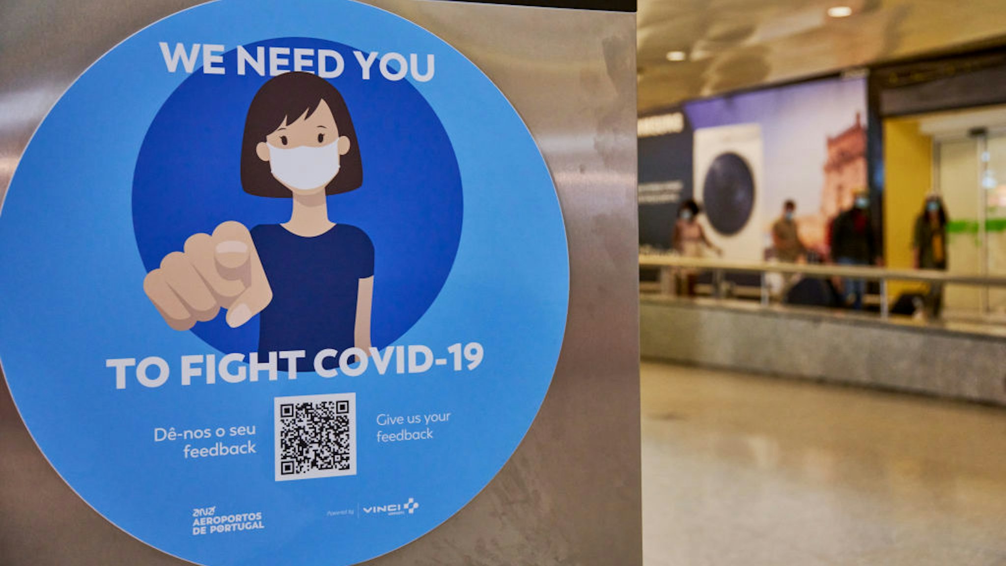 LISBON, PORTUGAL - JUNE 17: Mask-clad arriving travelers walk with their luggage behind a COVID-19 related advertising at the arrivals hall of Terminal 1 in Humberto Delgado International Airport a day after the country started issuing the first Immune certificates, as part of the European Union's COVID-19 Digital Certificate, during COVID-19 Coronavirus pandemic on June 17, 2021 in Lisbon, Portugal. Traveling becomes safer and easier for Portuguese residents as the vaccination certificates will be made available for all users of the country's National Health Service, and the DGS indicated that it will issue three different certificates, namely, the vaccination certificate, the test certificate, and the recovery certificate. (Photo by Horacio Villalobos#Corbis/Corbis via Getty Images)