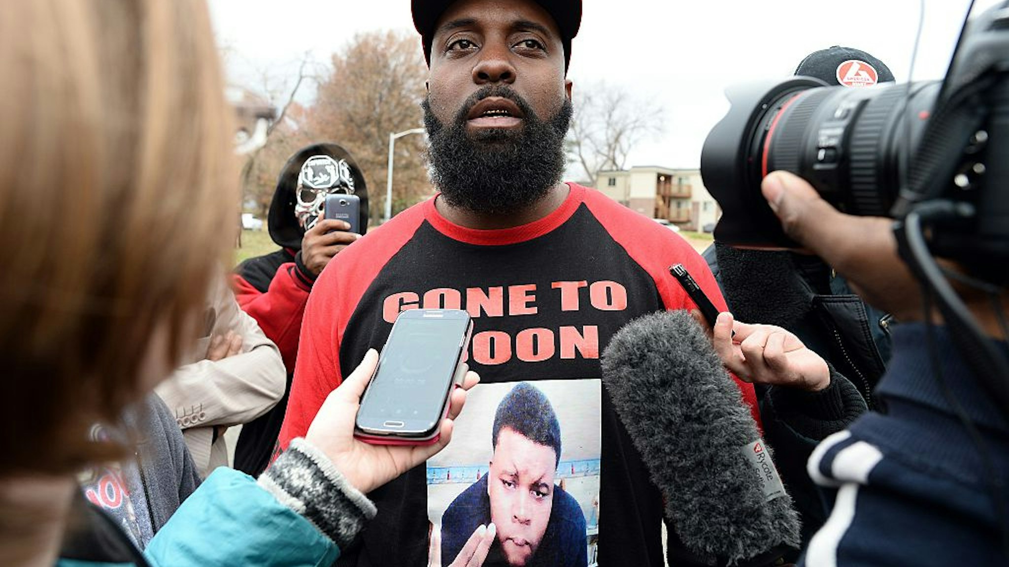 Michael Brown Sr. (C), the father of 18-year-old Michael Brown who was shot dead by a police officer, speaks to journalists as he distributes turkeys for Thanksgiving where his son was killed in Ferguson, Missouri, on November 22, 2014.