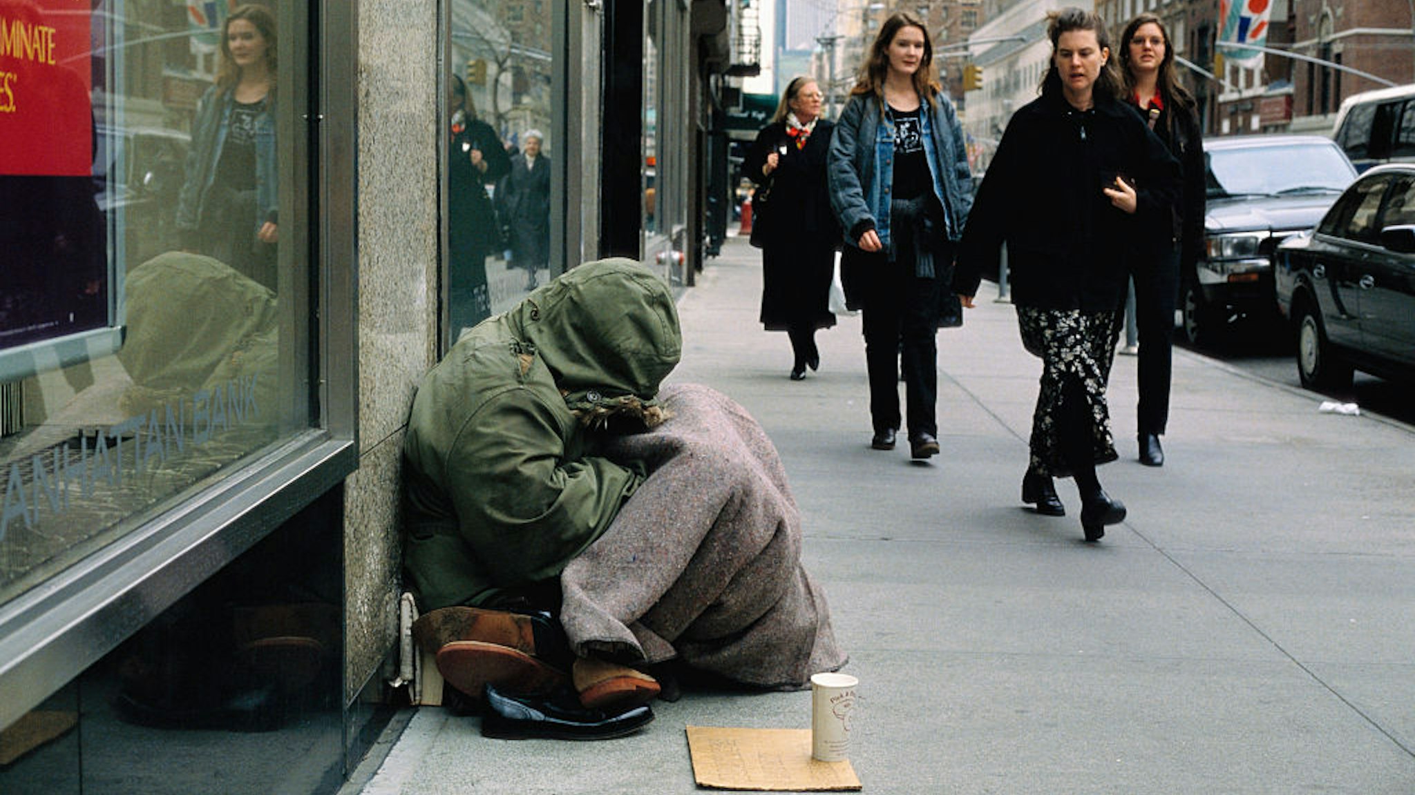 A group of women walk past a homeless woman begging for money along a city sidewalk. (Photo by © Viviane Moos/CORBIS/Corbis via Getty Images)
