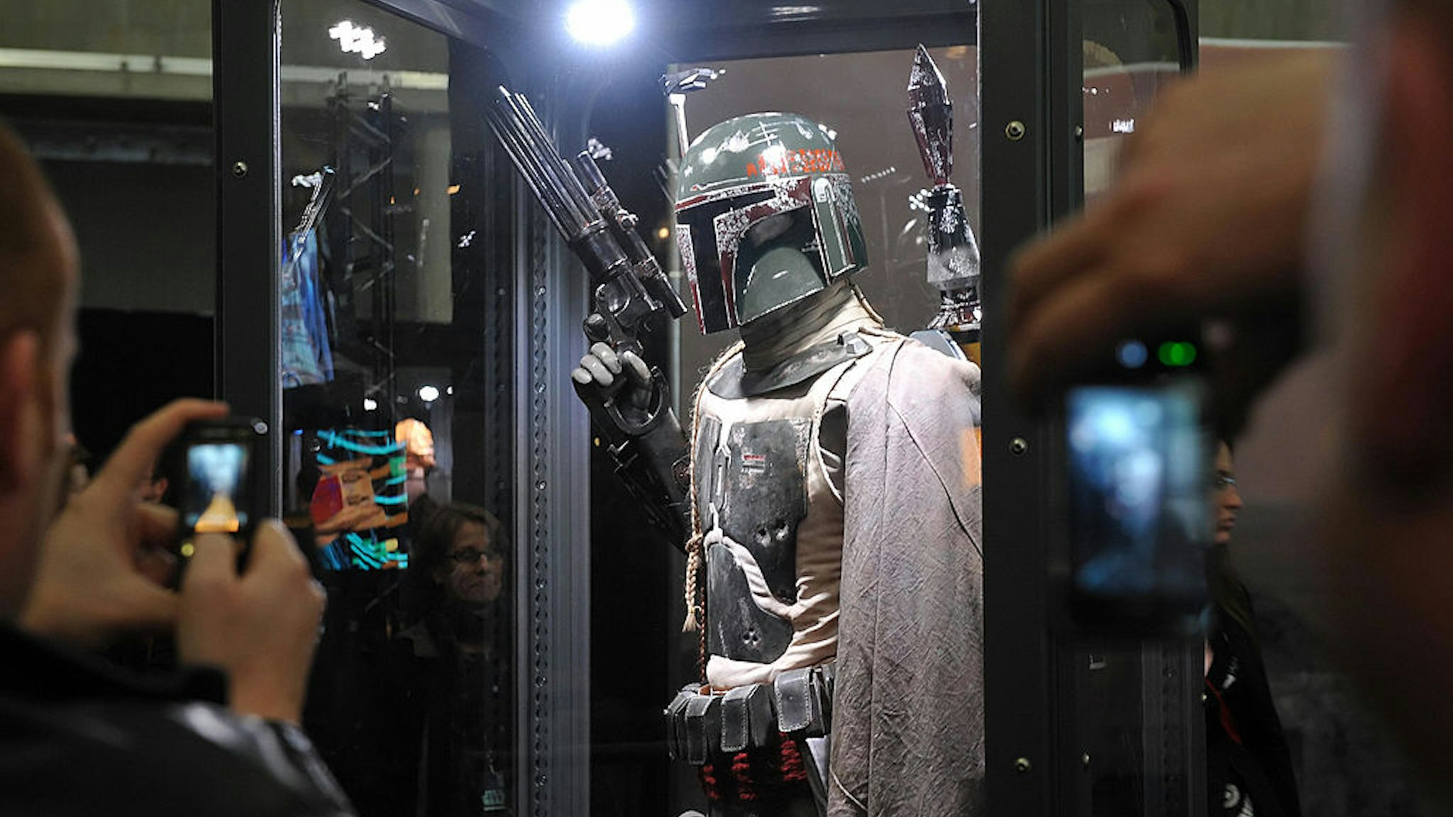 People take pictures of a Boba Fett model before the world premiere of 'Star Wars: A Musical Journey' at the O2 Arena in east London, on April 10, 2009.. The show features an extensive selection of composer John Williams' scores from all six Star Wars movies in a two-hour musical event which includes scenes from the movies, live narration and, at the O2, the 86 piece Royal Philharmonic Orchestra and Choir. AFP PHOTO/Leon Neal (Photo credit should read Leon Neal/AFP via Getty Images)
