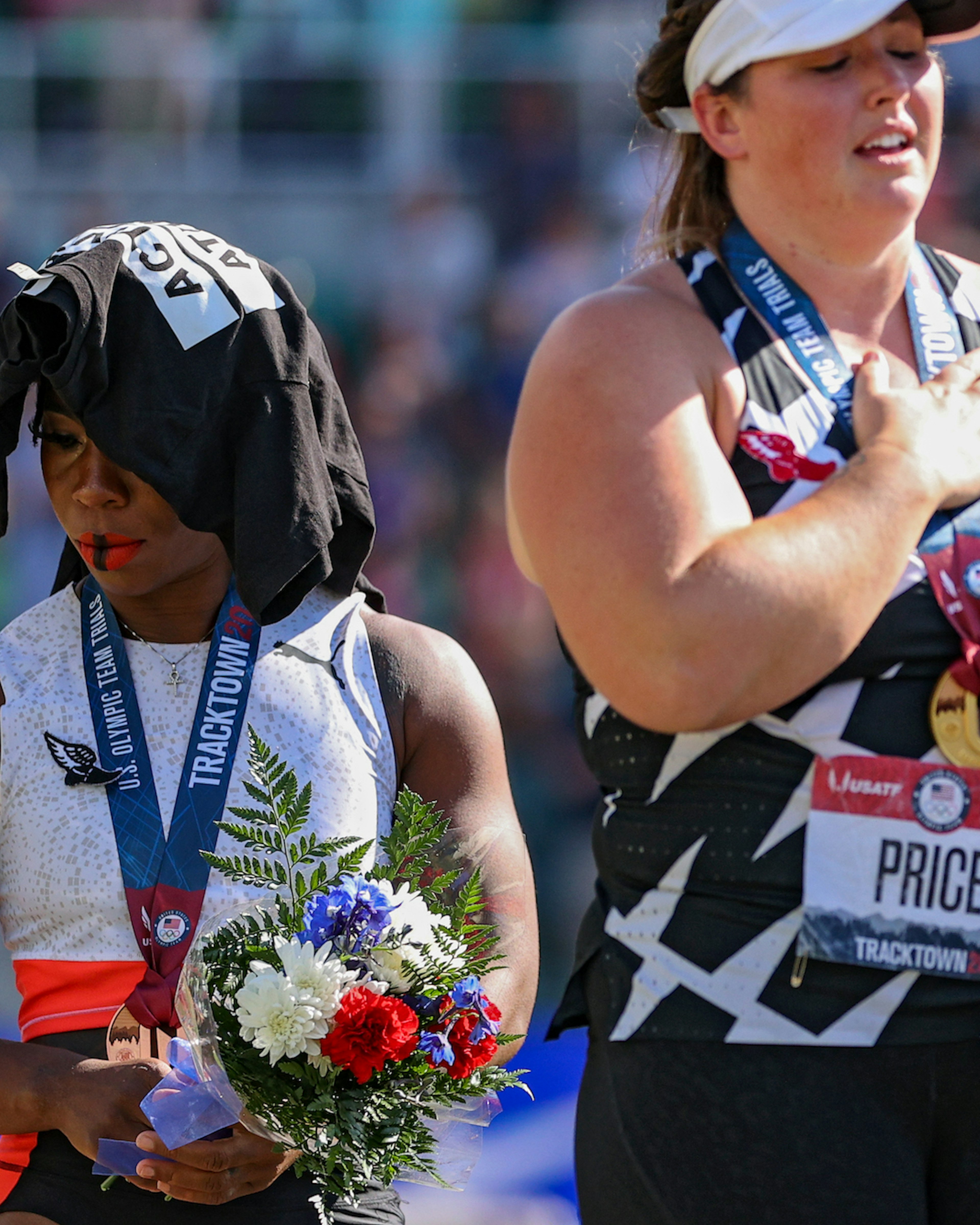 Gwendolyn Berry (L), third place, turns away from U.S. flag during the U.S. National Anthem as DeAnna Price (C), first place, also stands on the podium after the Women's Hammer Throw final on day nine of the 2020 U.S. Olympic Track &amp; Field Team Trials at Hayward Field on June 26, 2021 in Eugene, Oregon. In 2019, the USOPC reprimanded Berry after her demonstration on the podium at the Lima Pan-American Games. (Photo by Patrick Smith/Getty Images)