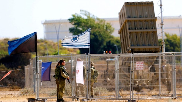 Israeli soldiers man a position in the southern city of Ashkelon, near an Iron Dome missile defence system, on May 15, 2021. - Israel pummelled the Gaza Strip with air strikes today, killing 10 members of an extended family and demolishing a building housing international media outlets, as Palestinian militants fired back barrages of rockets. The sharp uptick in violence, now in its sixth day, claimed more dead as clashes also swept the occupied West Bank.